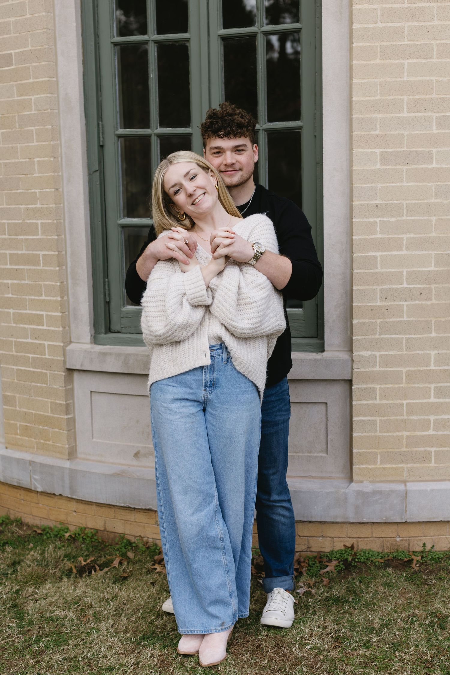 A romantic photoshoot sequence against a beige brick building with windows.