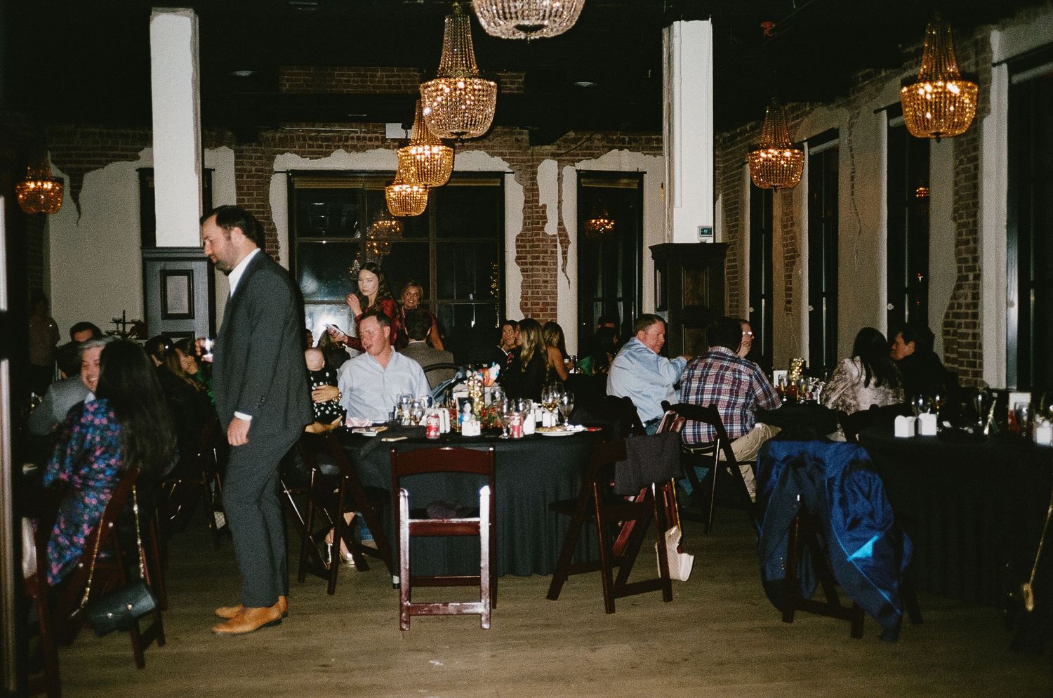 Evening reception venue with industrial decor and string lights illuminating the space.