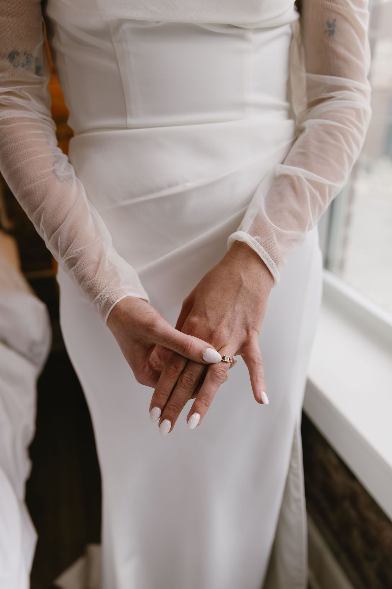 Close-up details of a white wedding dress showing delicate fabric and design elements.