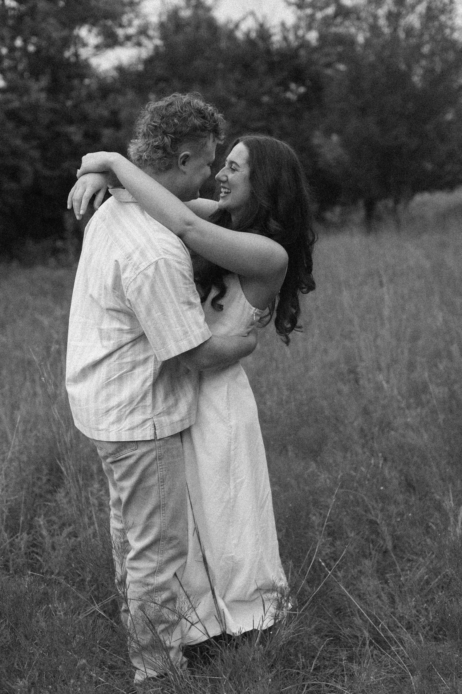 A romantic black and white photo sequence of a couple dancing in a grassy field.