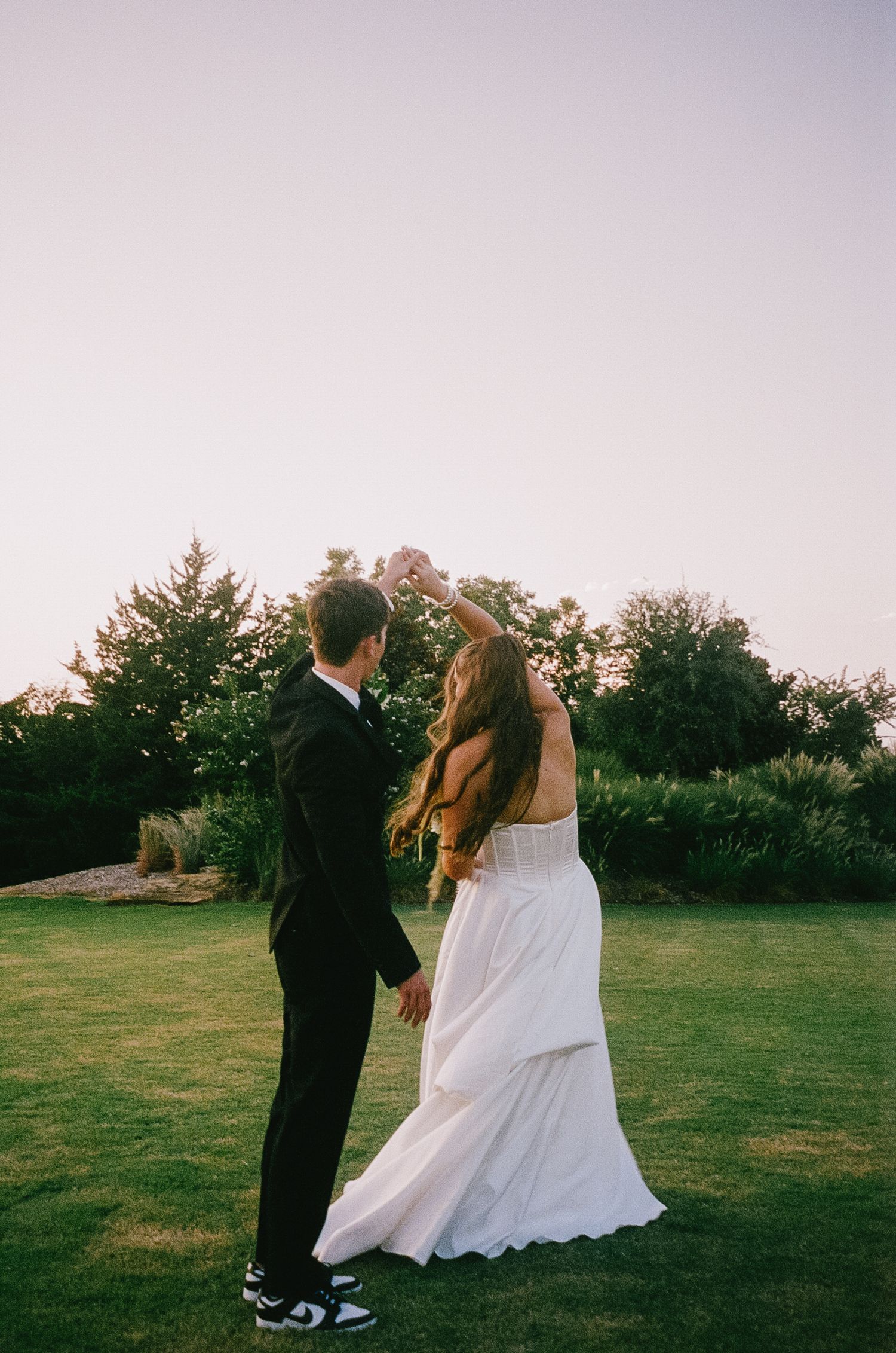 Romantic sunset wedding portrait in garden setting with formal attire.