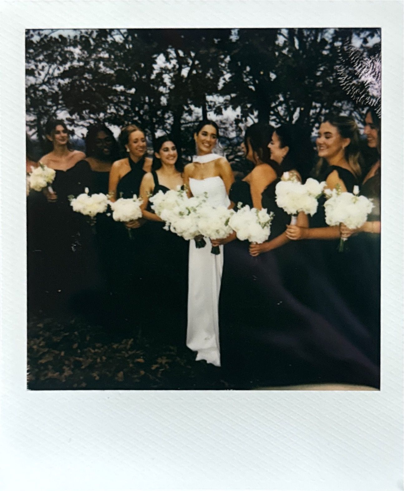 Wedding party holding white bouquets in a vintage polaroid style photograph.