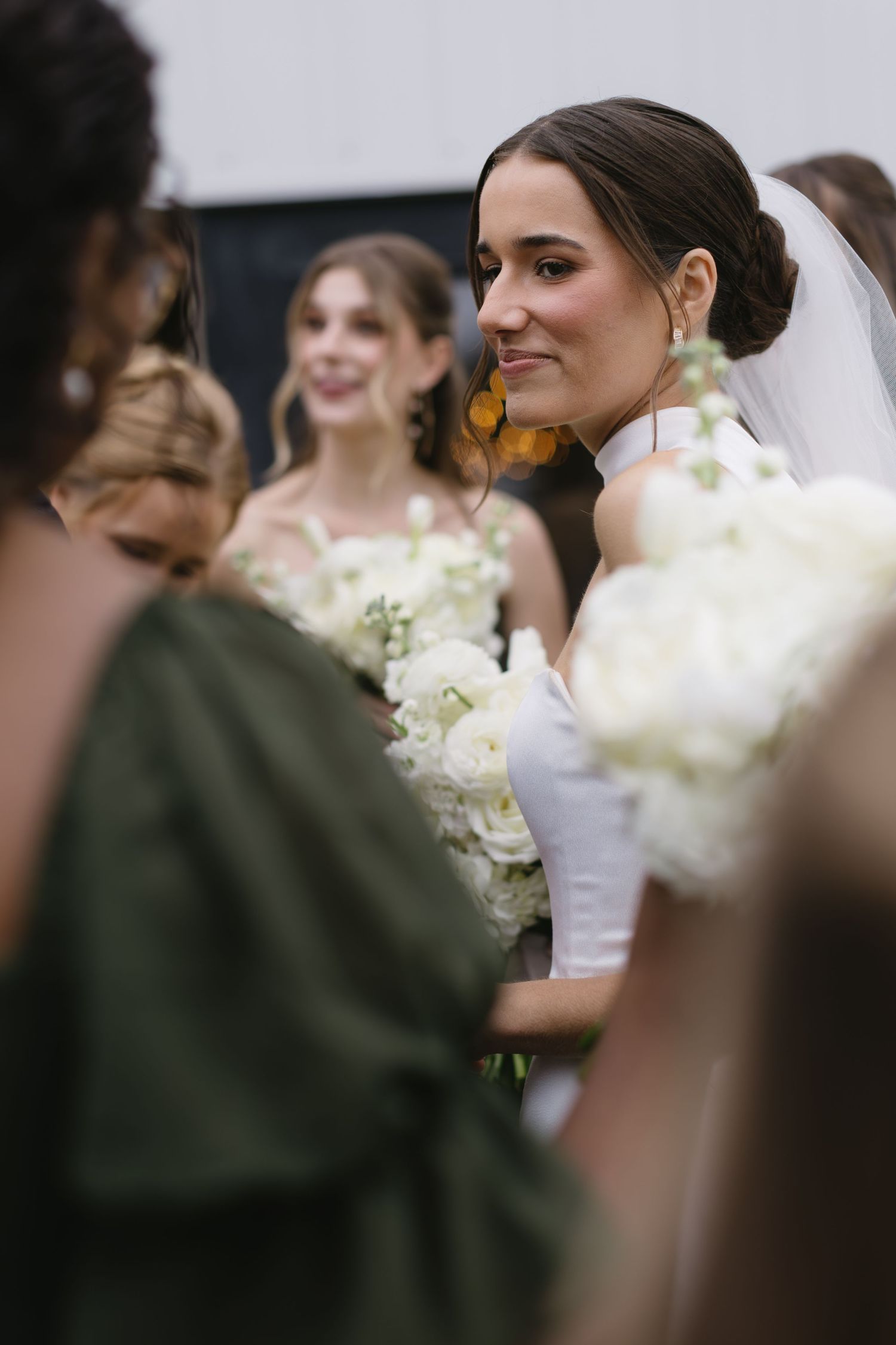 Wedding party members sharing joyful moments with white floral bouquets.