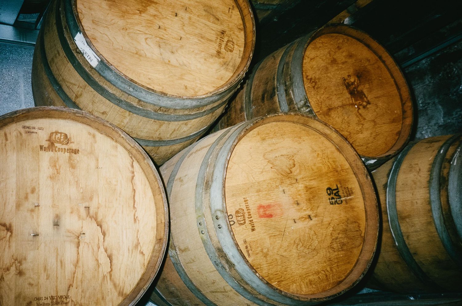 Wooden wine barrels stacked in rows at a winery or event space.