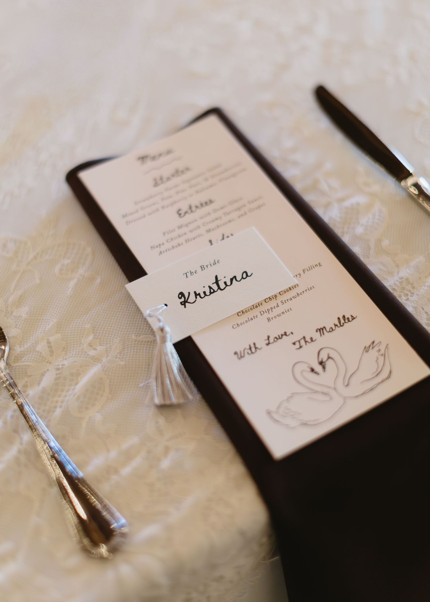 Wedding invitation suite featuring elegant swan design and calligraphy on textured paper.