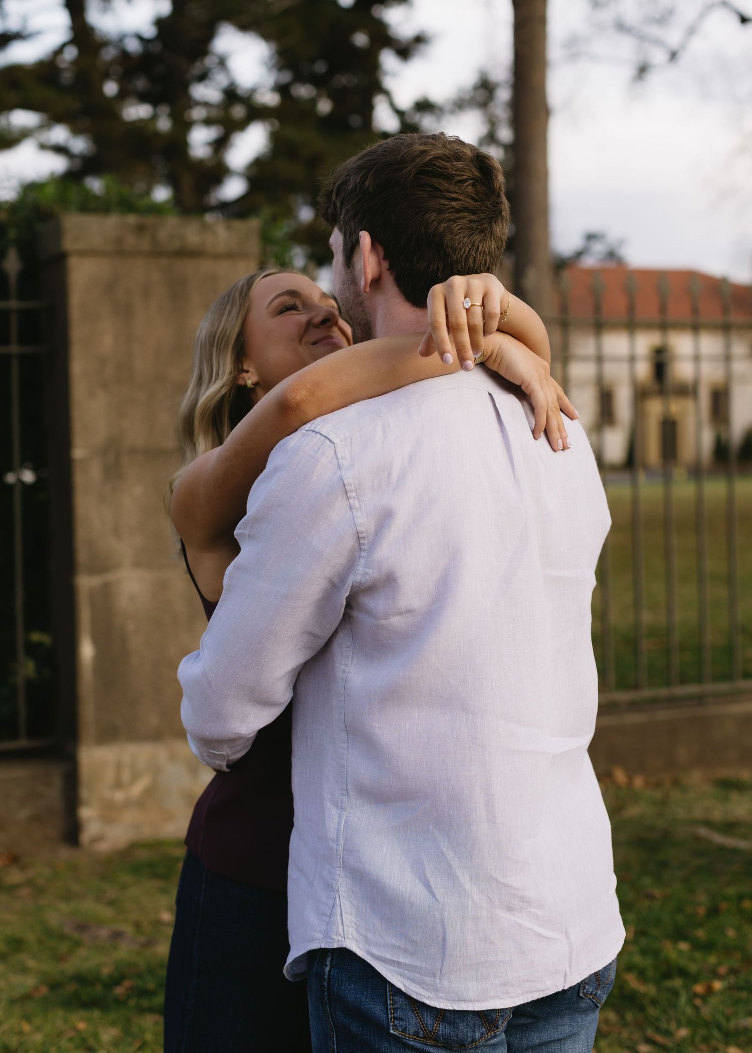 A couple embraces outdoors in a romantic photoshoot sequence showing tender moments against a natural backdrop.