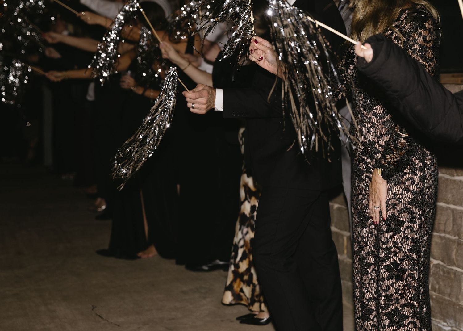 Wedding guests enjoying festivities on dance floor during evening celebration.