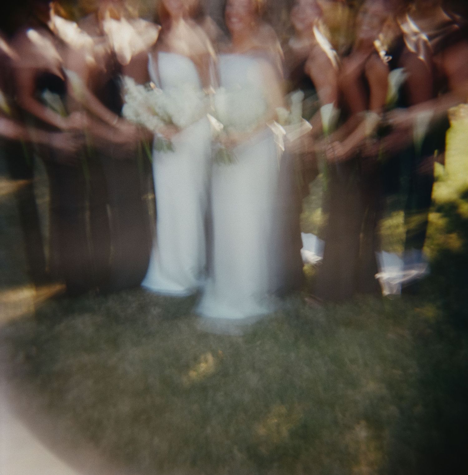 Blurred motion of dancers on a reception floor with white dresses visible.