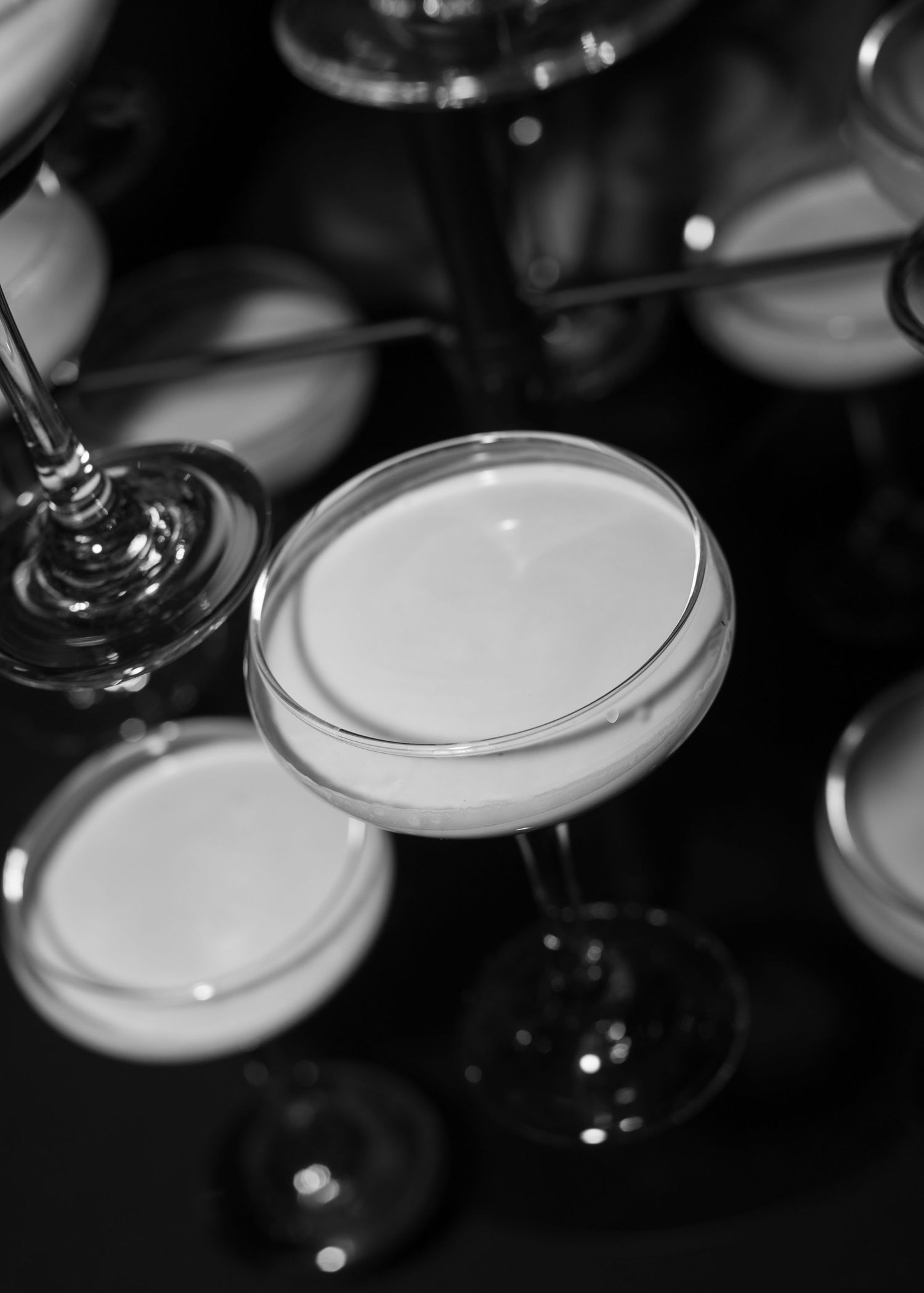 Artistic close-up of champagne cocktails in coupe glasses creating abstract pattern.