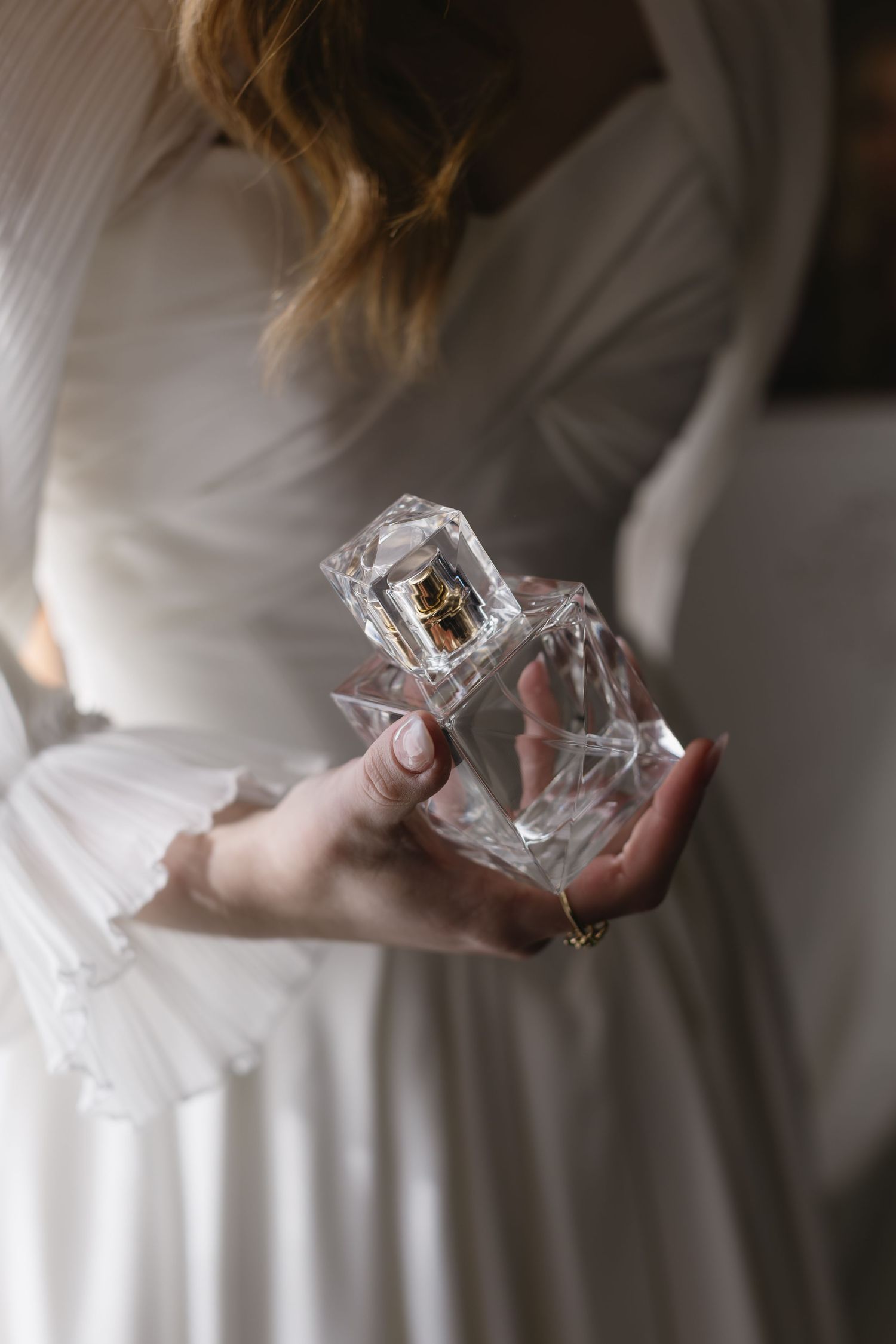 Close-up shots of hands holding delicate jewelry pieces wrapped in plastic.