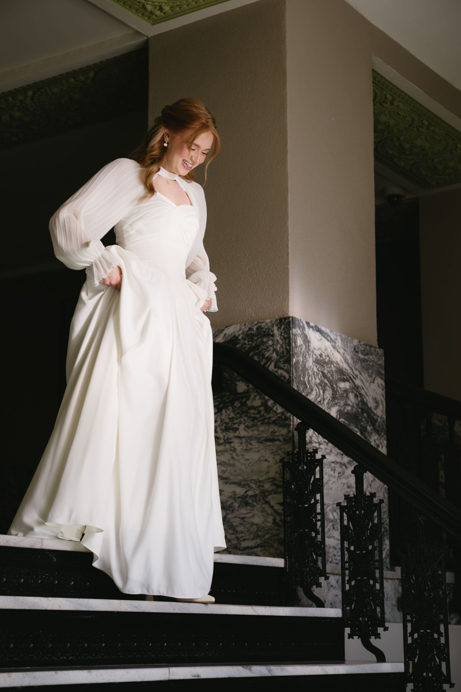 Artistic bridal portrait on stairs showing flowing white dress movement.