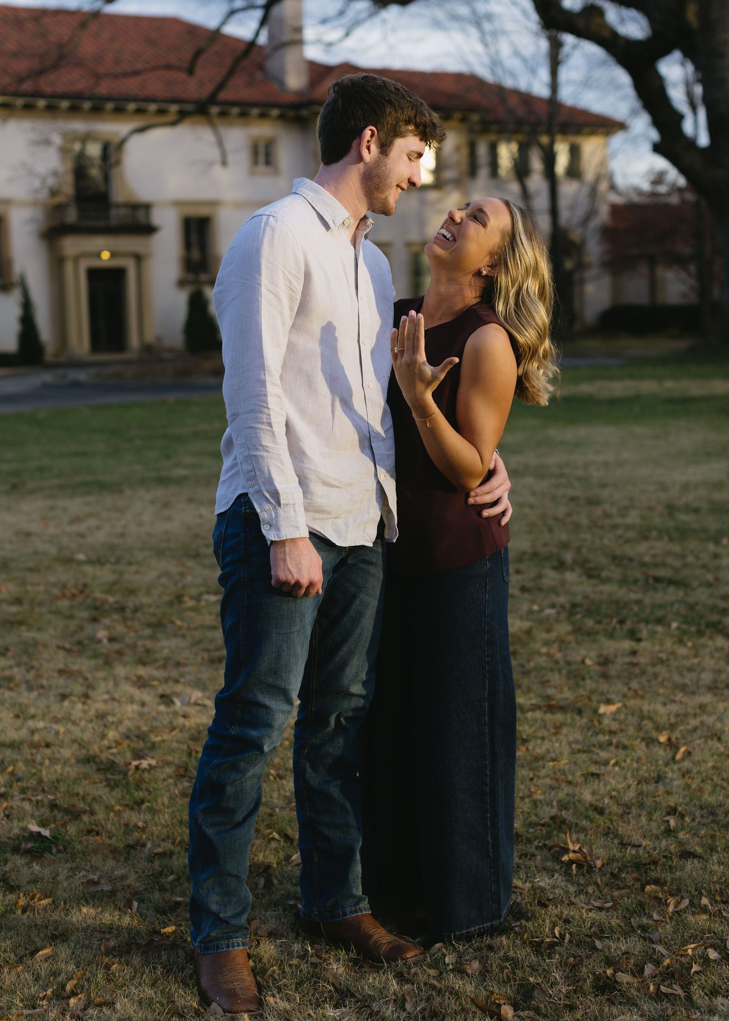 A couple shares romantic moments outdoors against a historic building backdrop.