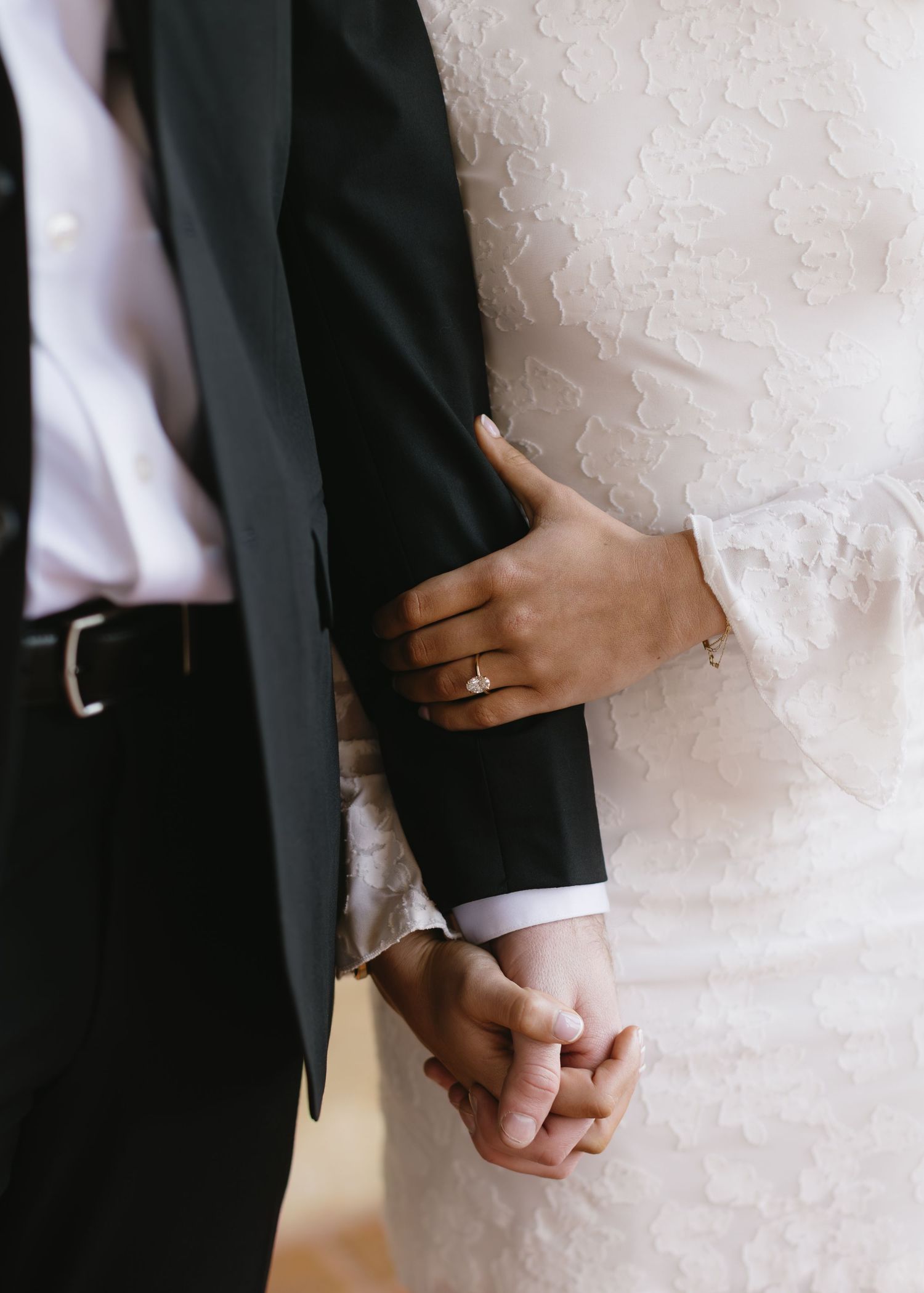 A series of black and white photos showing hands clasped together in a romantic wedding moment against a white background.
