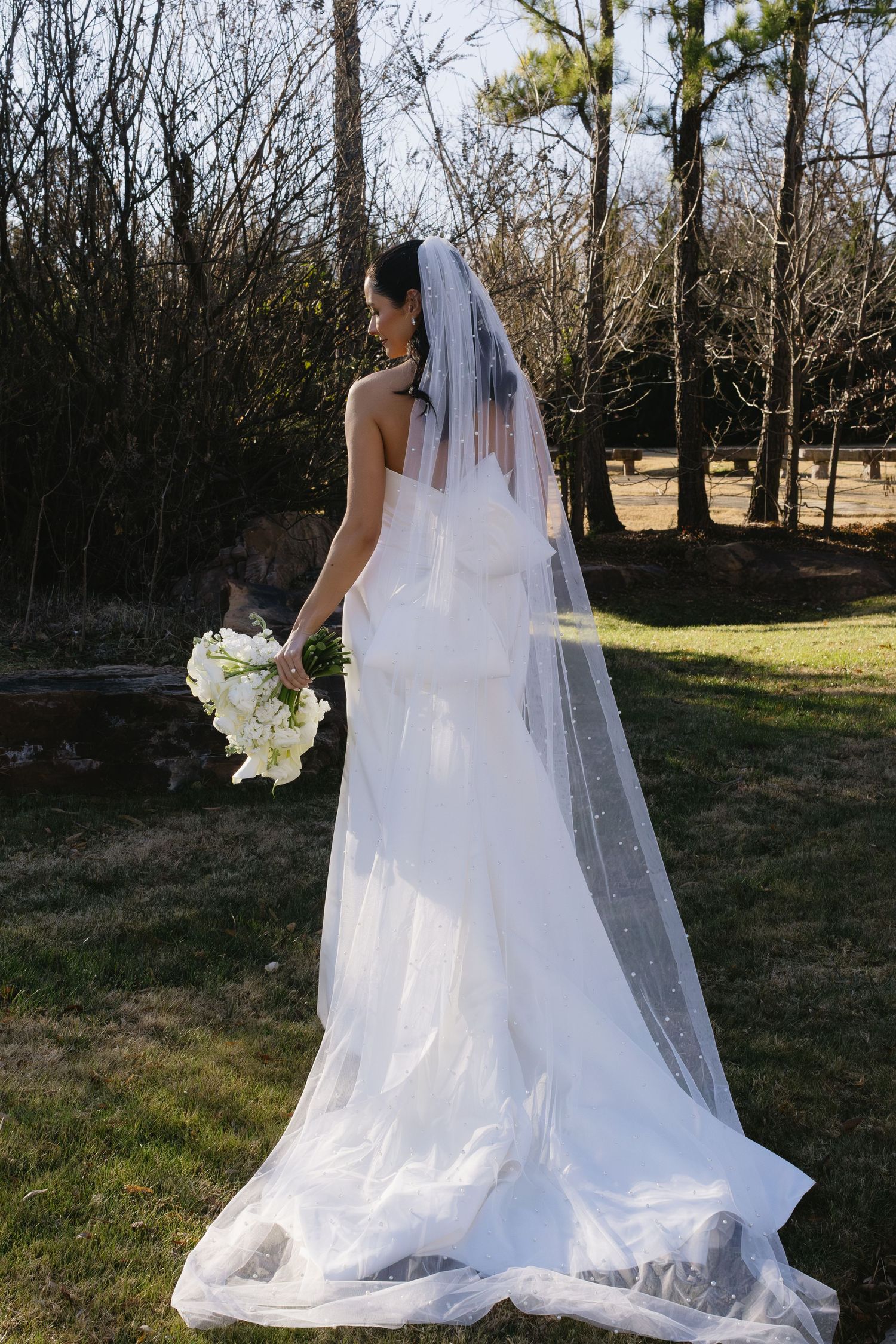 Elegant white wedding dress with flowing veil captured in a series of outdoor shots.