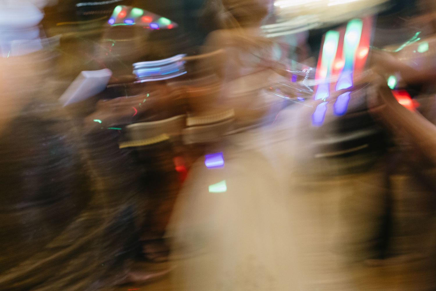 Abstract motion-blur photograph of wedding reception dancing with colorful lights.