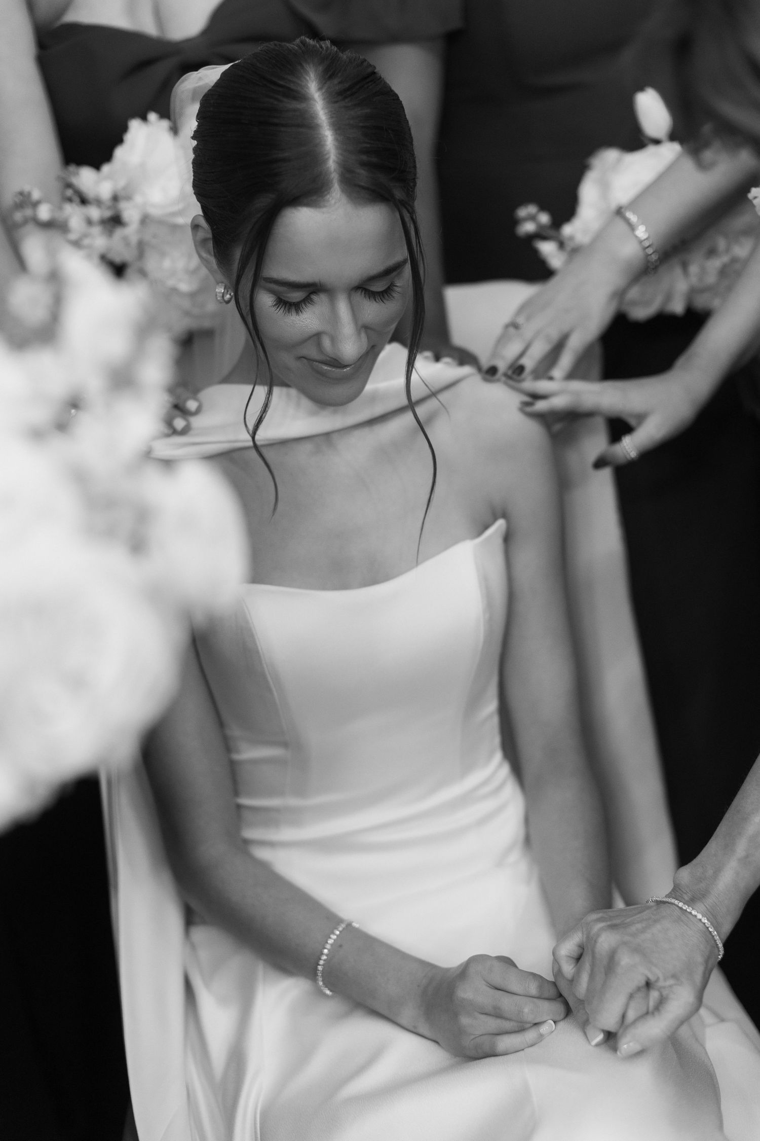 Close-up of elegant white wedding dress details during preparation.