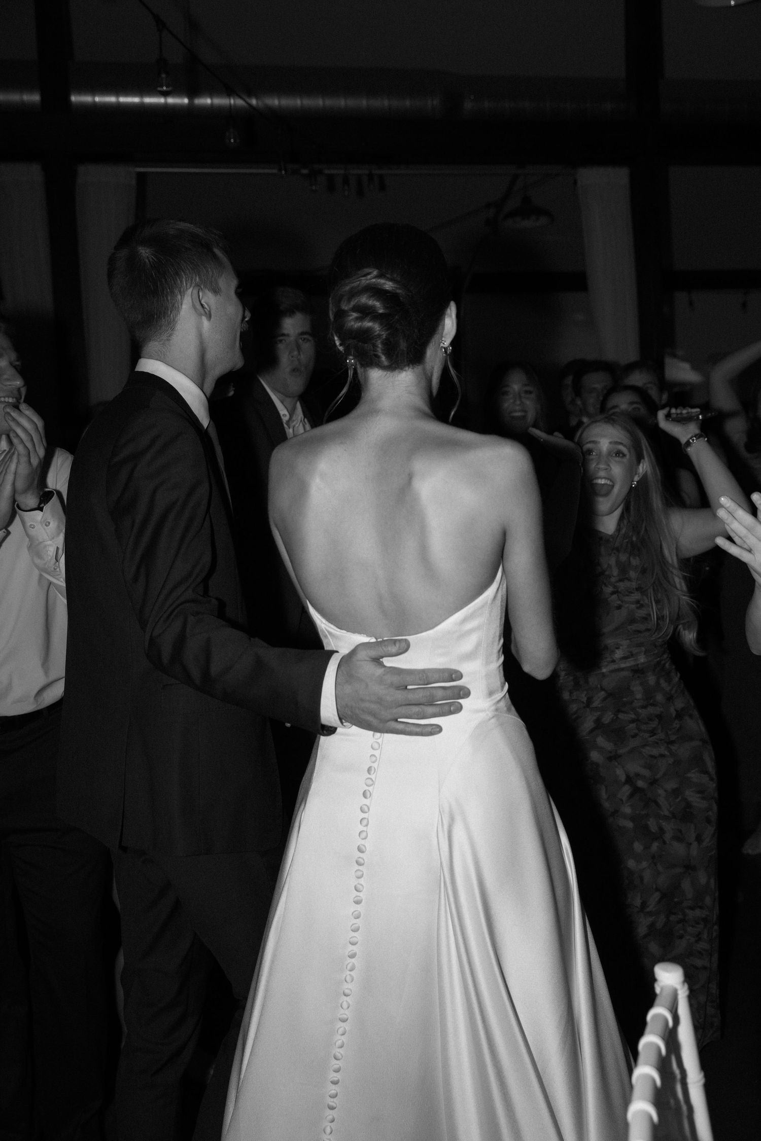 Back detail of an elegant white wedding dress with delicate button closures down the spine.