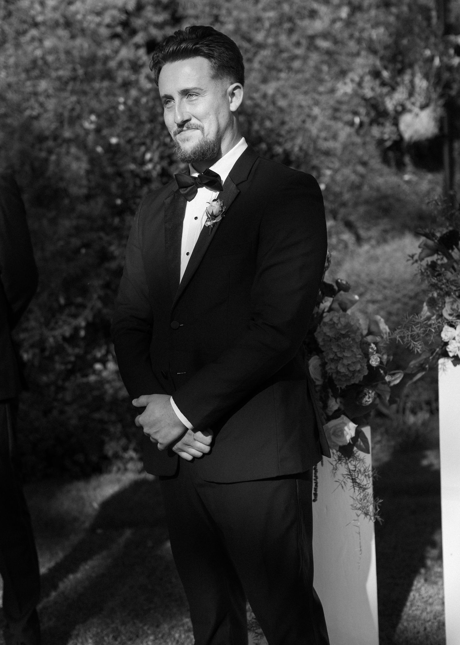Black and white portraits of groomsmen sharing emotional moments outdoors.