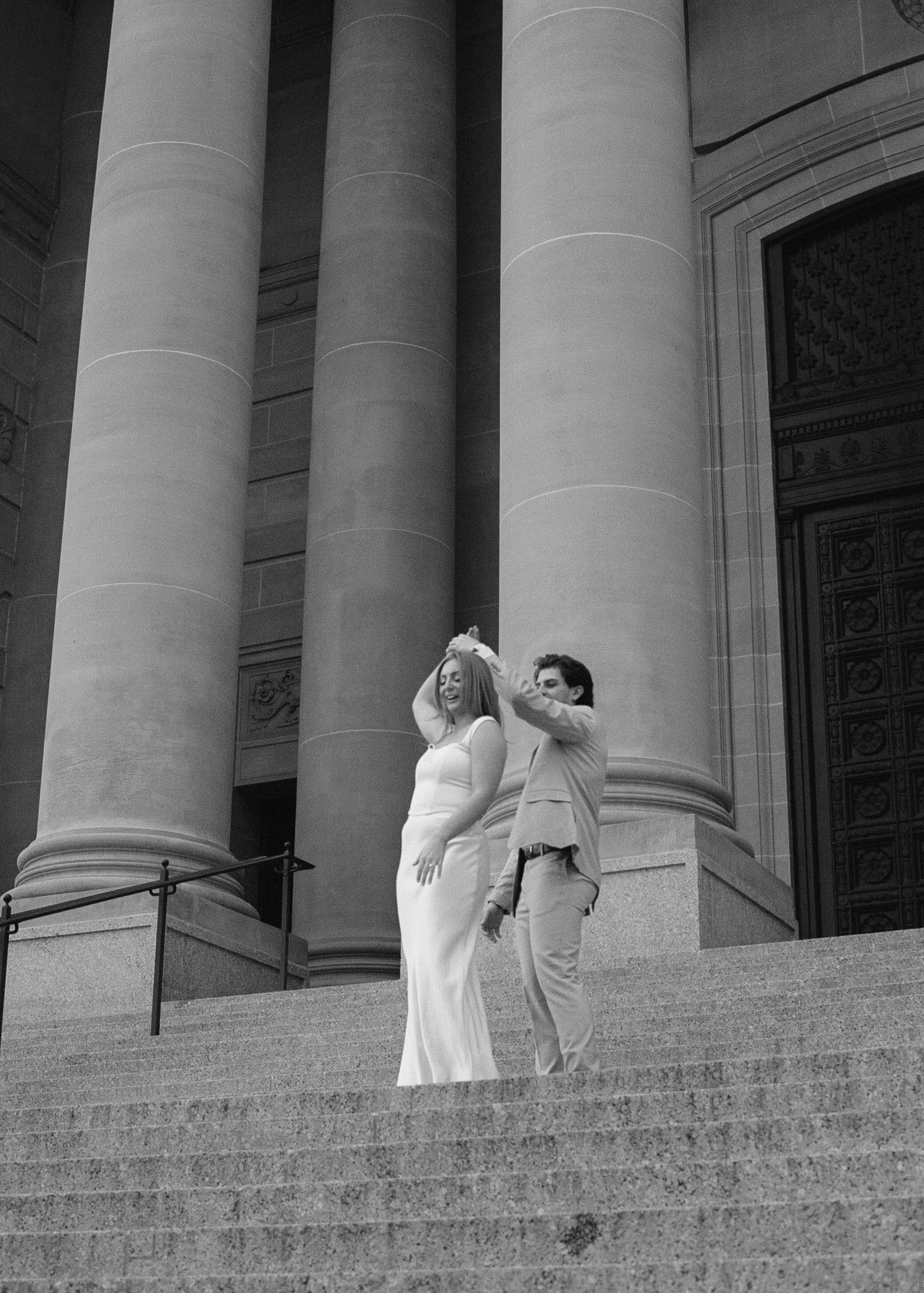 Series of silhouettes showing a couple ascending grand stone steps between classical columns.