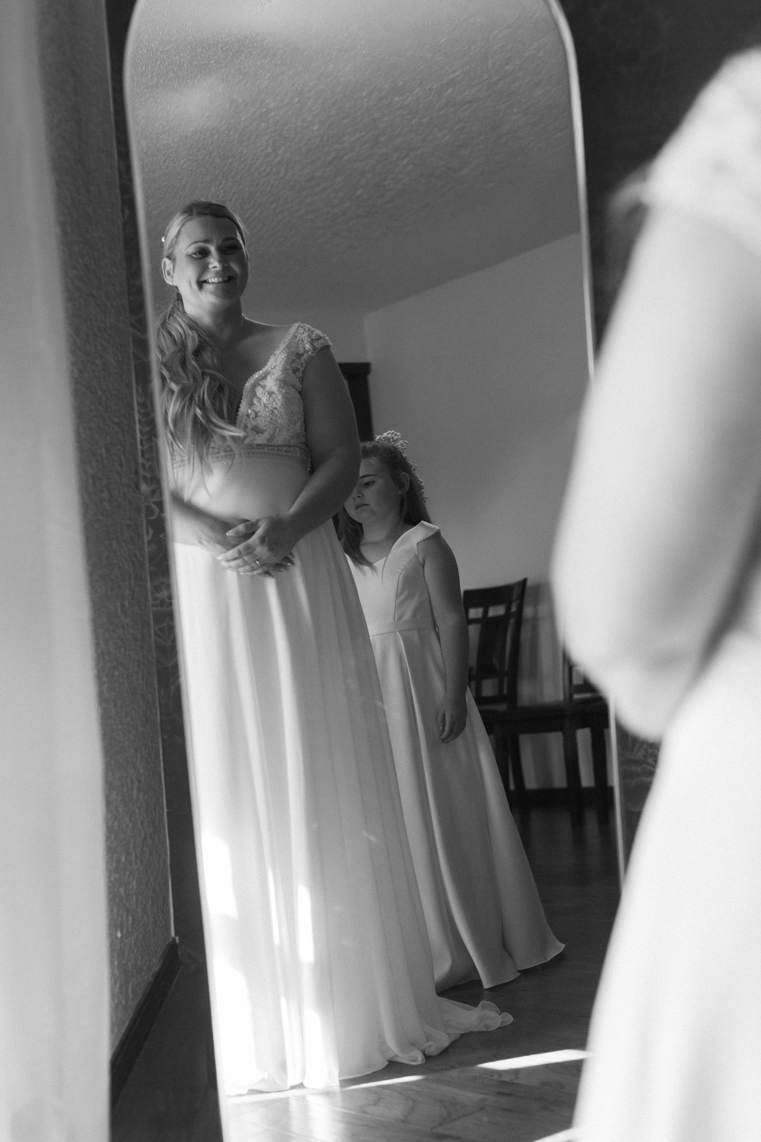 A black and white mirror reflection showing wedding dress preparations.