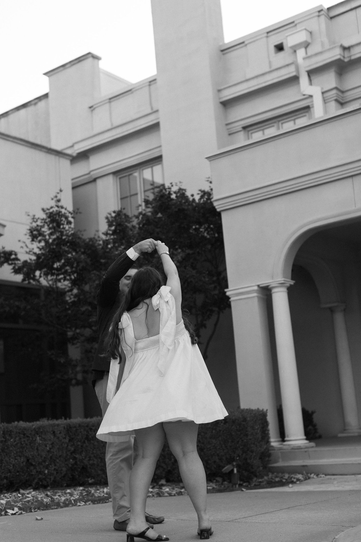 A series of playful dance poses captured at a white columned building entrance.