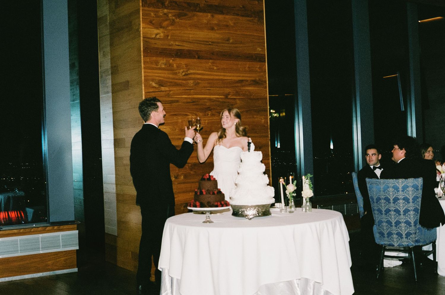 Dark reception venue with wooden walls and white tablecloths.
