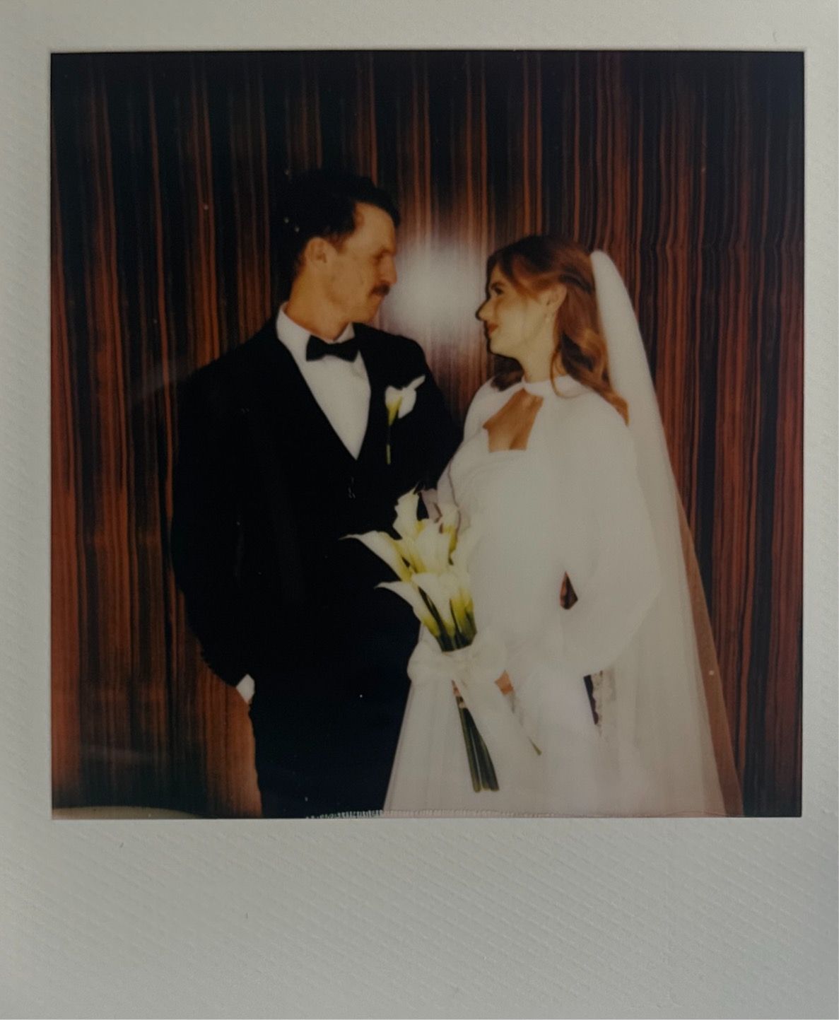 Vintage-style wedding portraits in warm tones against wood paneling.