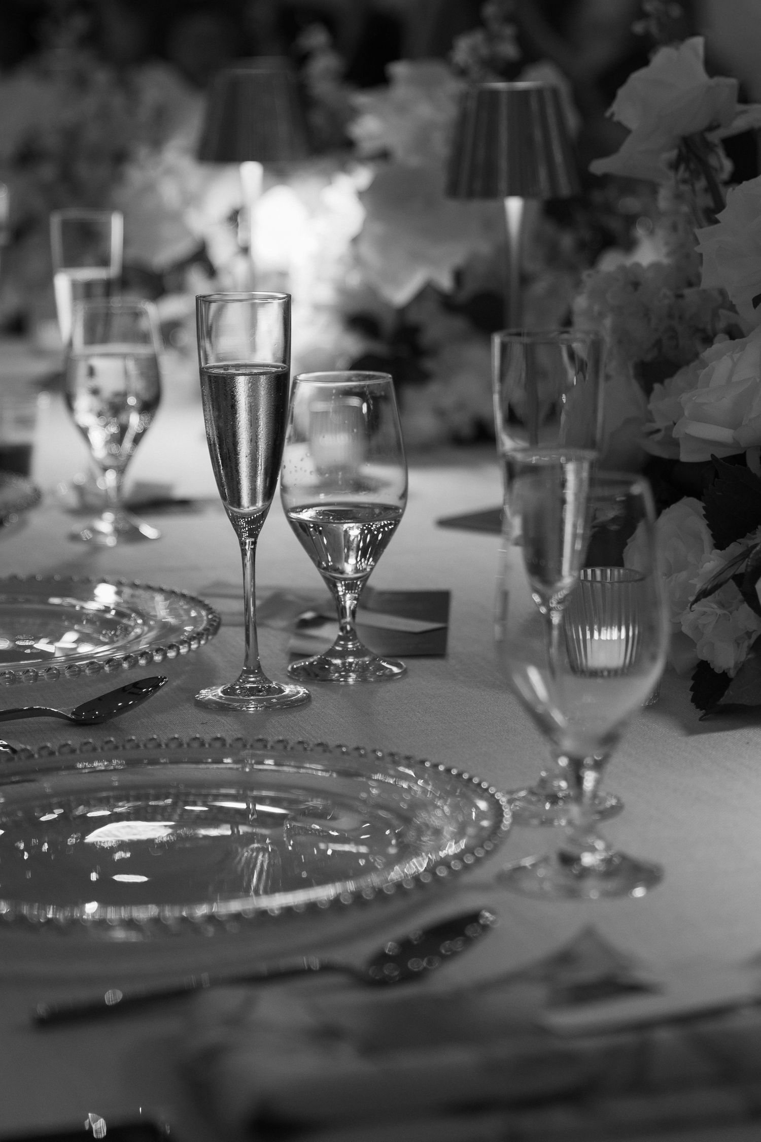 Black and white table setting with wine glasses and elegant place settings.