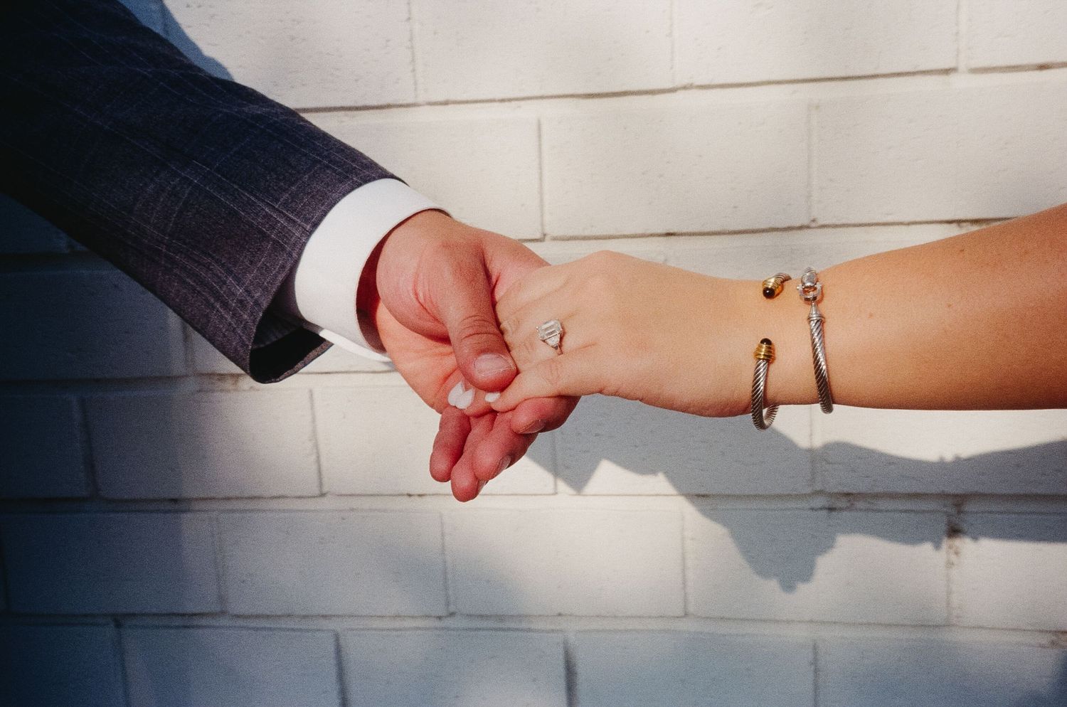 Hands reaching out to touch each other in a sequence of artistic black and white photographs.