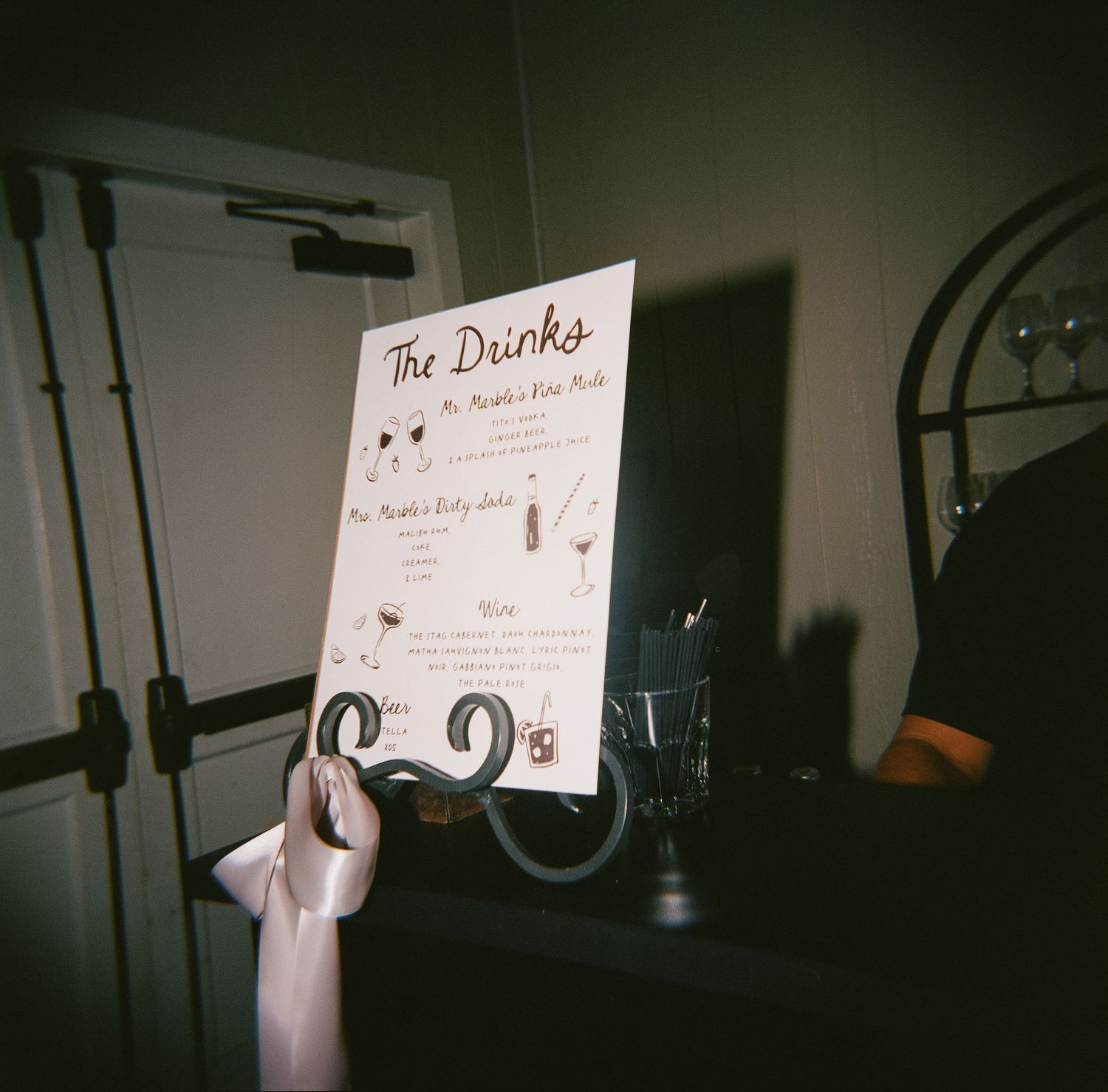 Close-up shots of wedding signage and drink menus being held against a dark background.