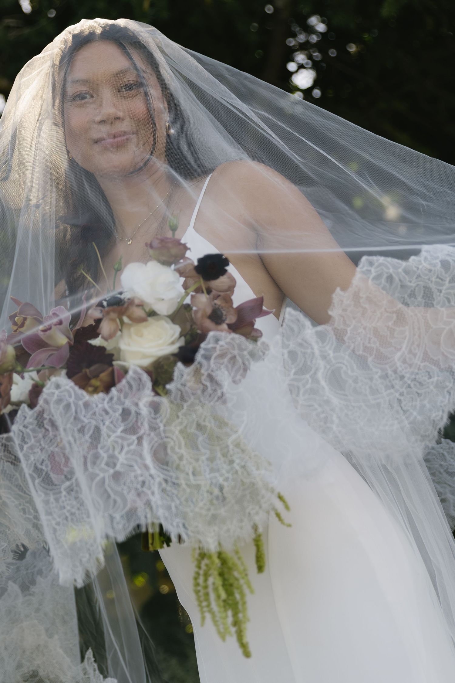 Close-up shots of bride with delicate lace veil and mixed floral bouquet.