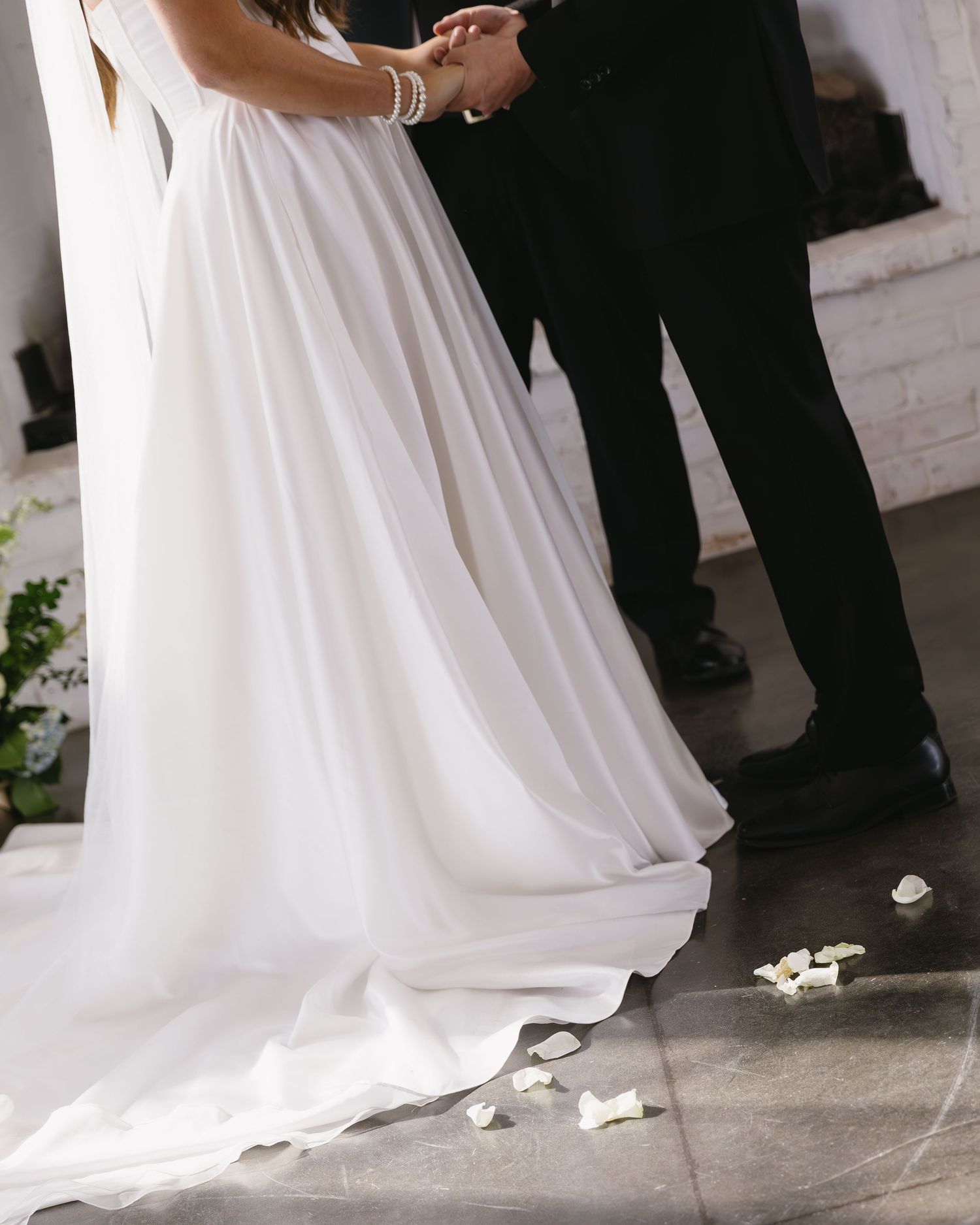 Close-up of flowing white wedding dress during ceremony.