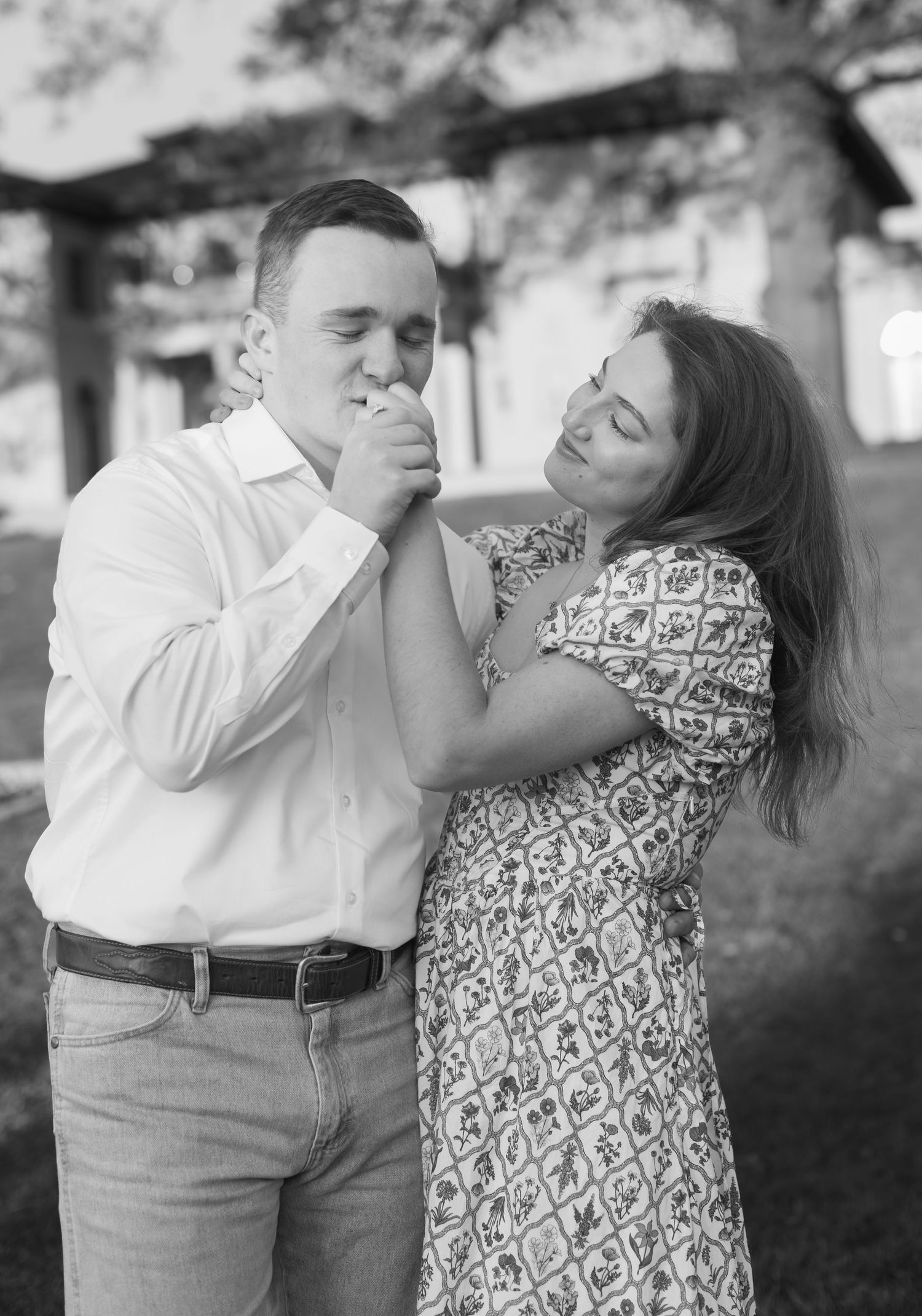 A playful black and white photo series of a couple sharing lighthearted moments outdoors.