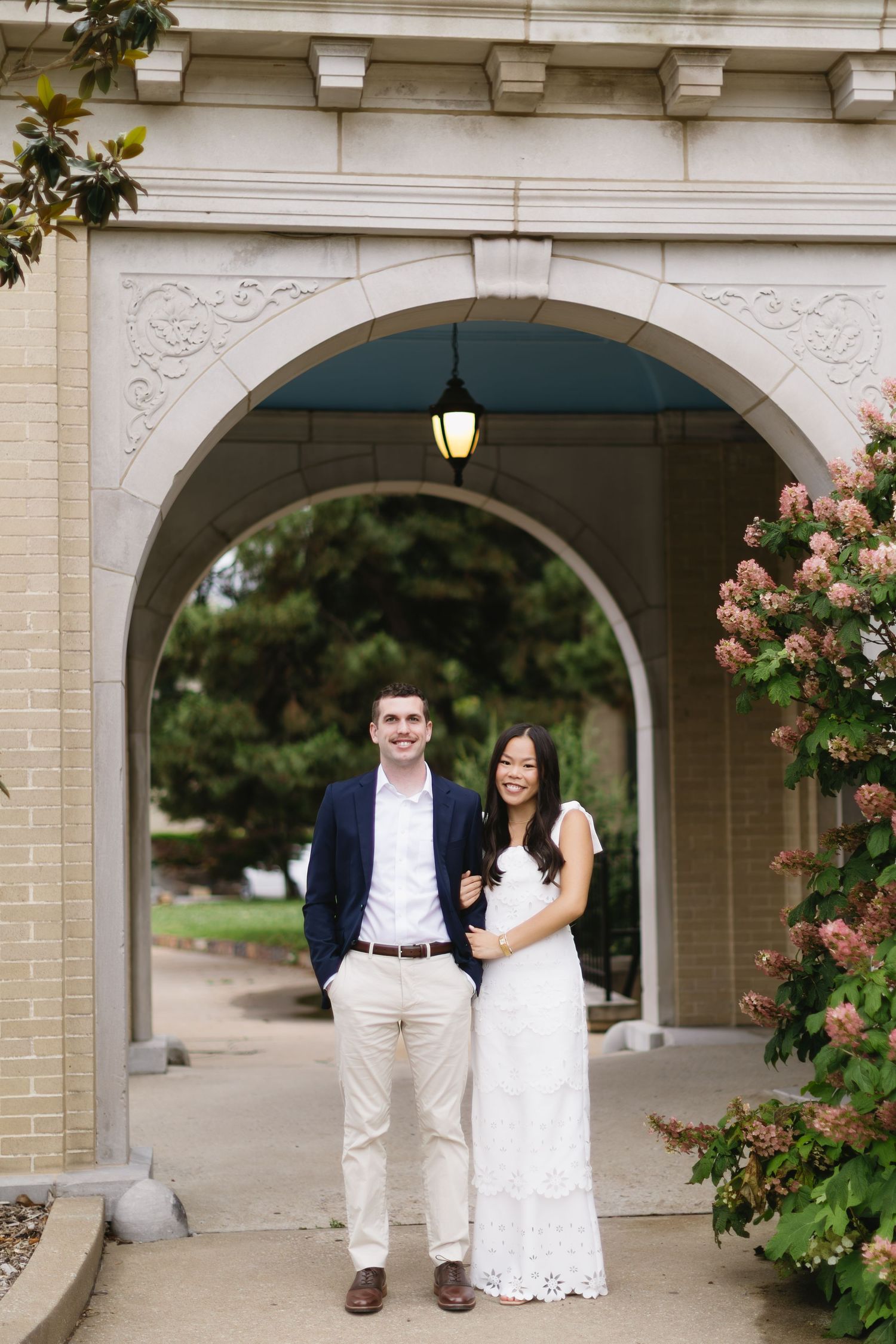 An elegant outdoor photoshoot under stone archways decorated with climbing pink roses.