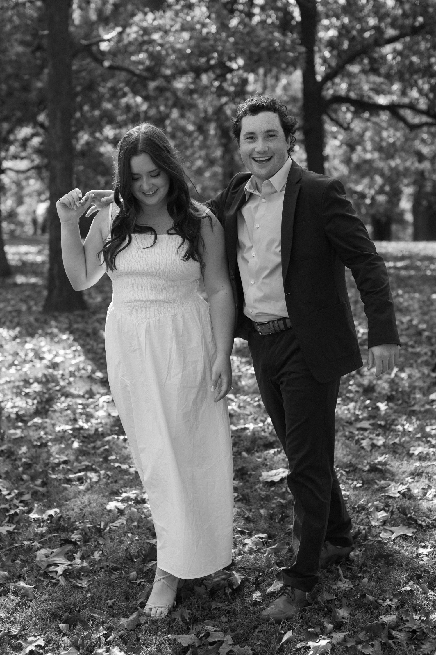 Romantic black and white photo series of a couple laughing together in an autumn garden setting.