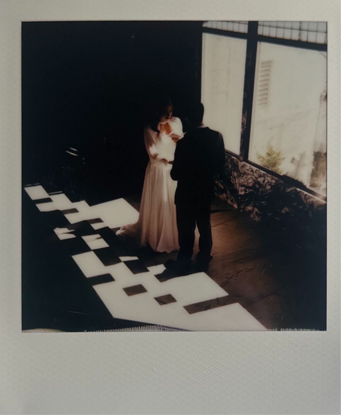 Artistic black and white polaroid photos displayed from a wedding celebration.