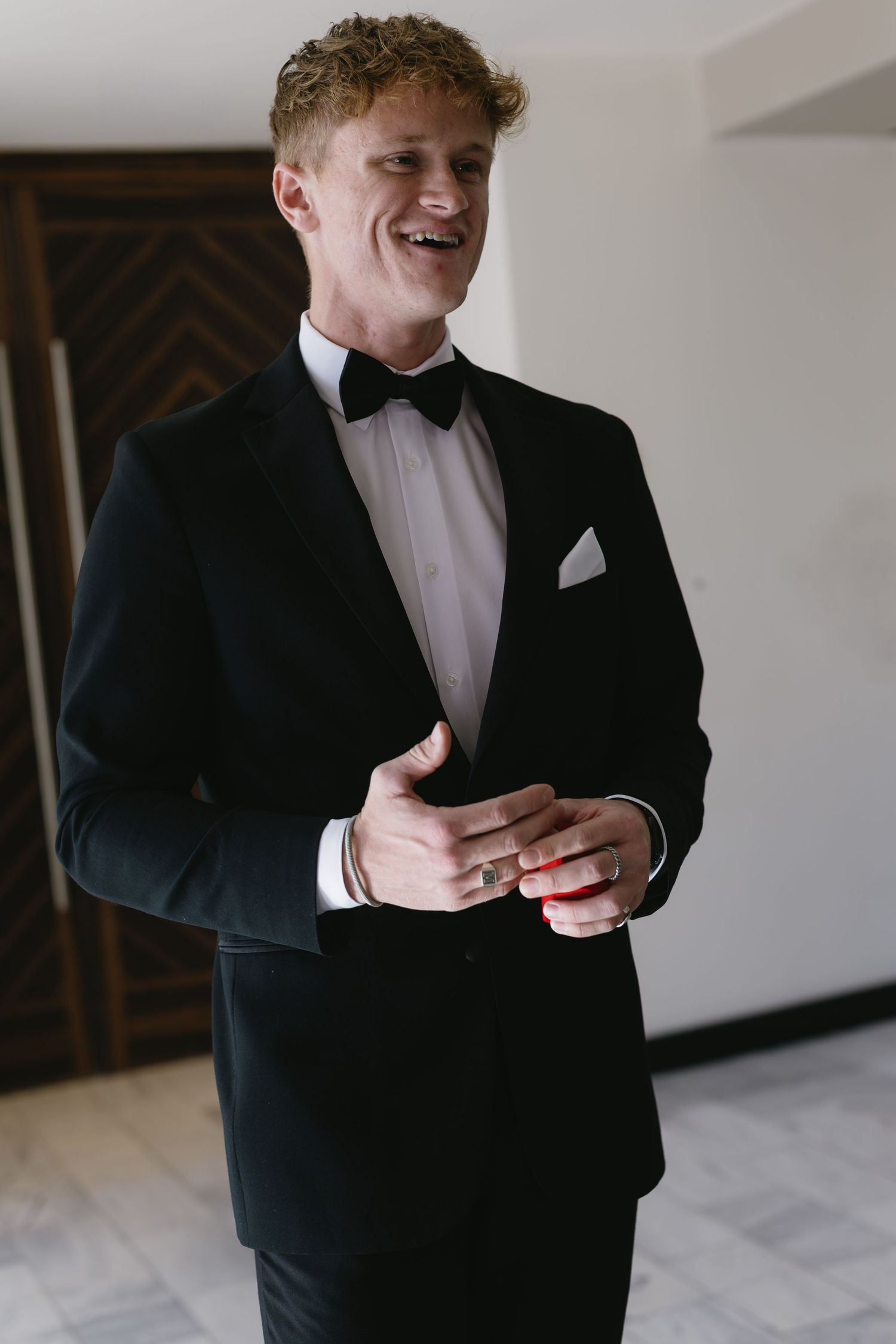 Candid moments of groom adjusting his formal attire before the ceremony.