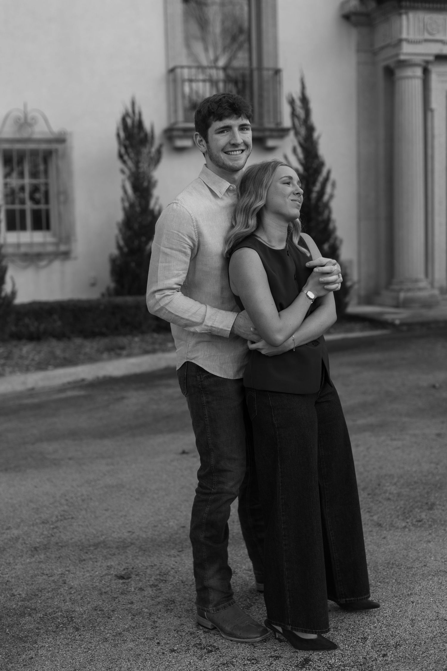 A couple shares tender moments while sitting together on steps in black and white photography.