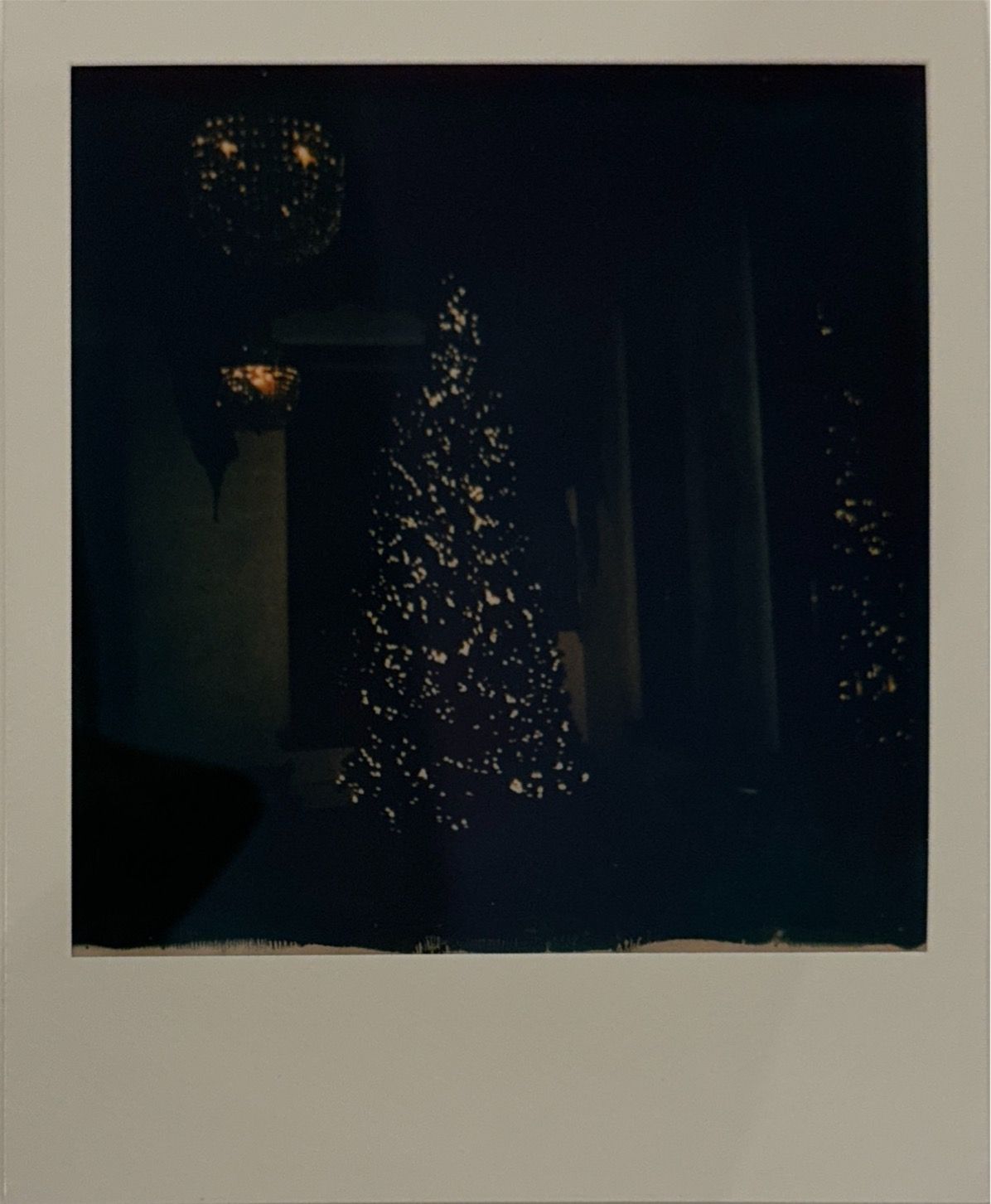 A dark moody image sequence showing a Christmas tree with twinkling lights in a dimly lit room.