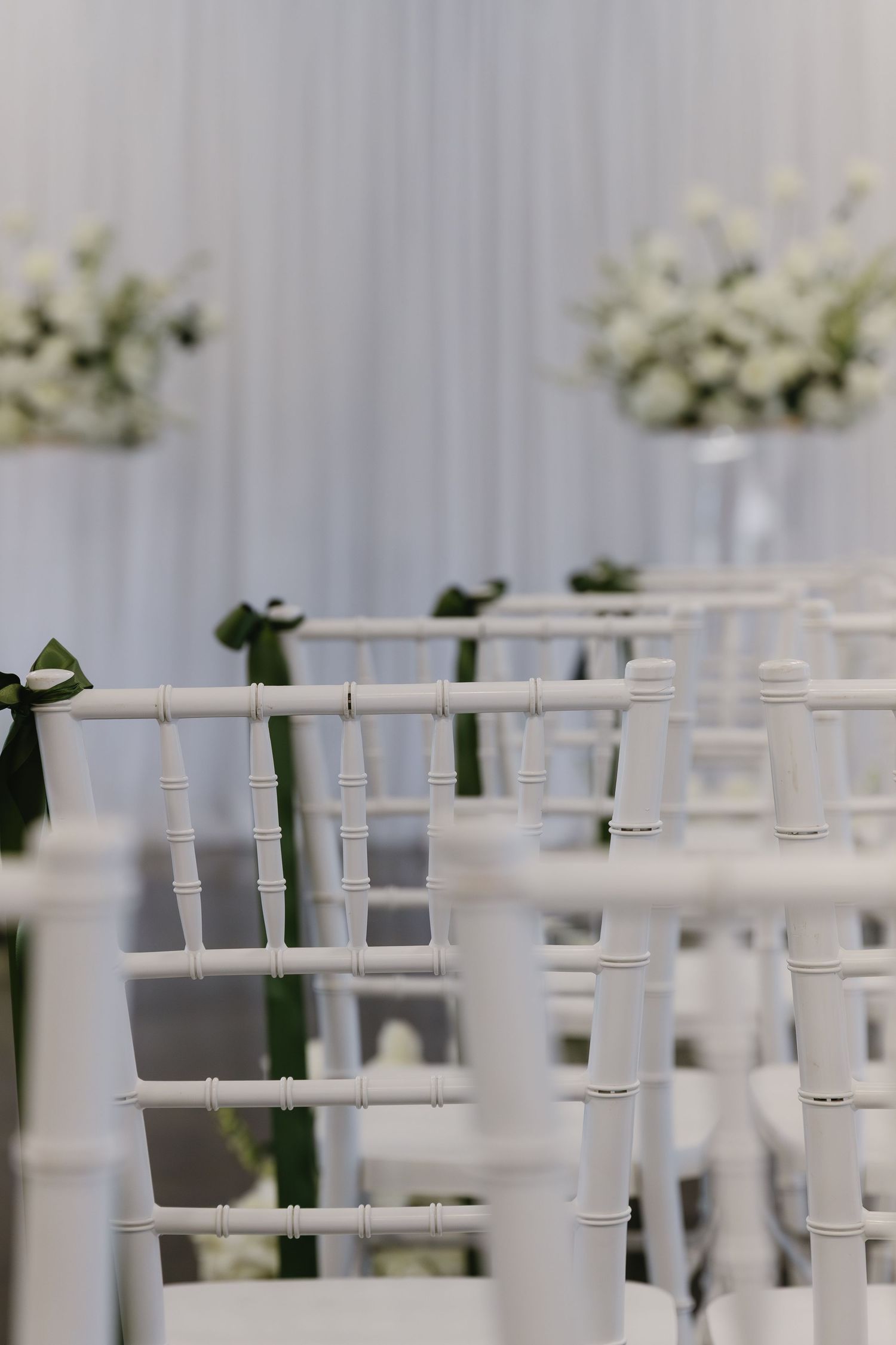White chiavari chairs arranged in neat rows for an elegant wedding ceremony setup.