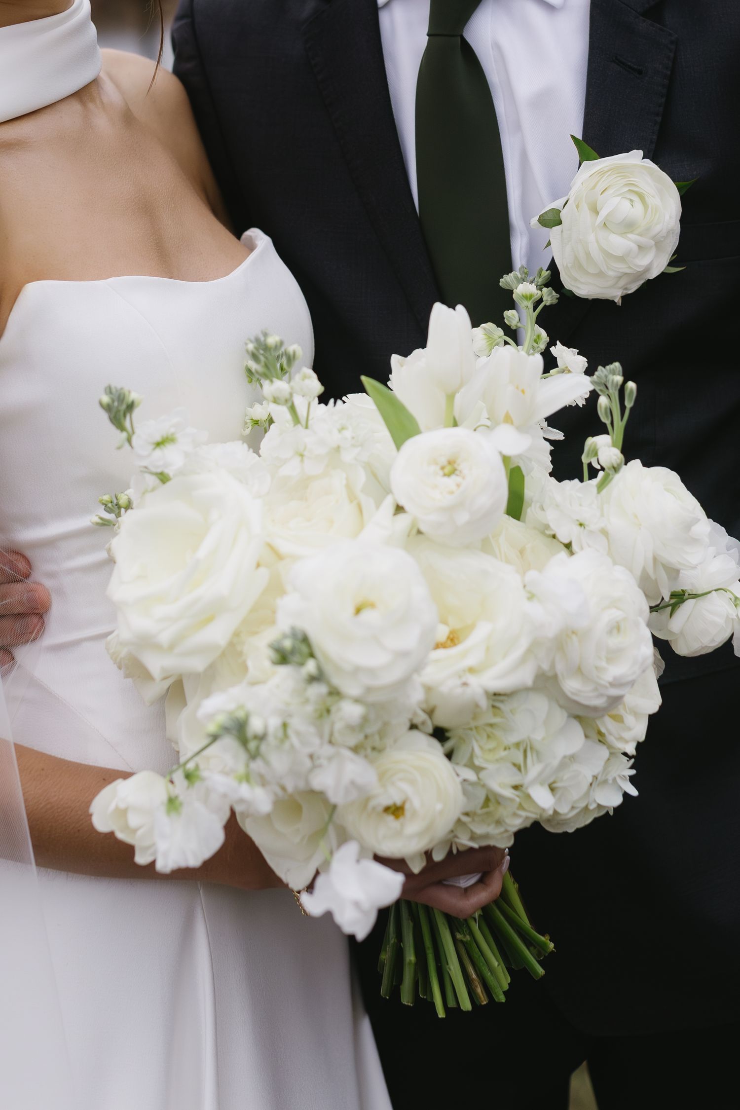 Elegant white rose and peony bouquet against black and white formal attire.