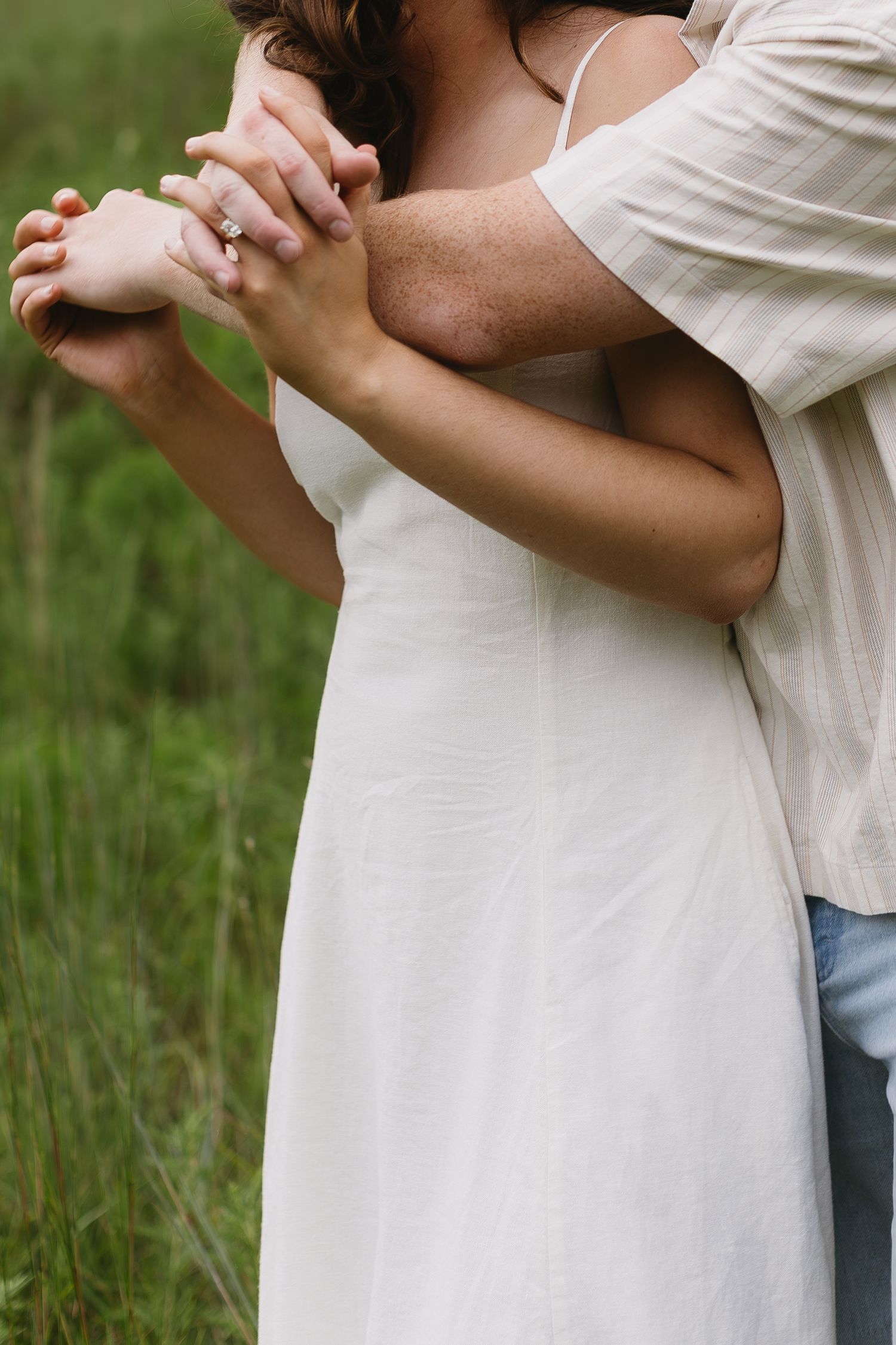 Detail shots of a couple in white clothing embracing outdoors against a natural green backdrop.