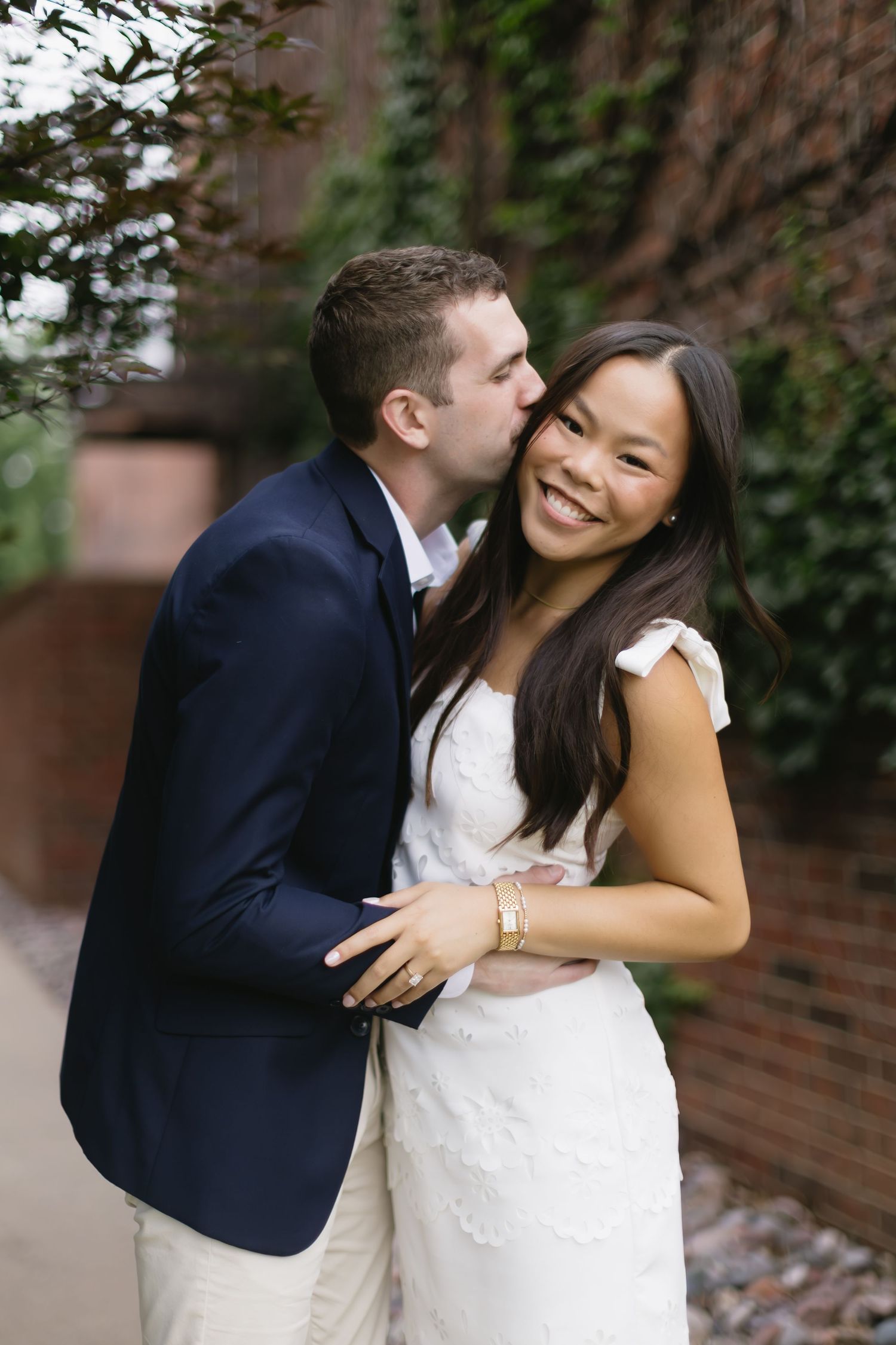 A joyful outdoor photo session against an ivy-covered brick wall backdrop.