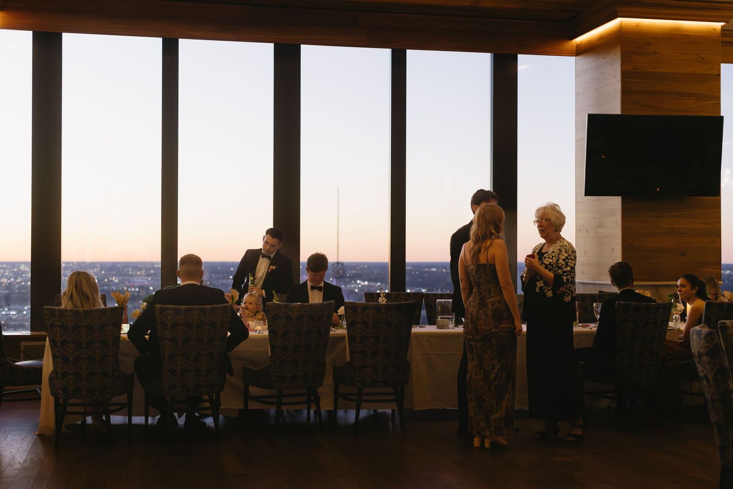 A panoramic view of a modern event space with floor-to-ceiling windows at sunset.