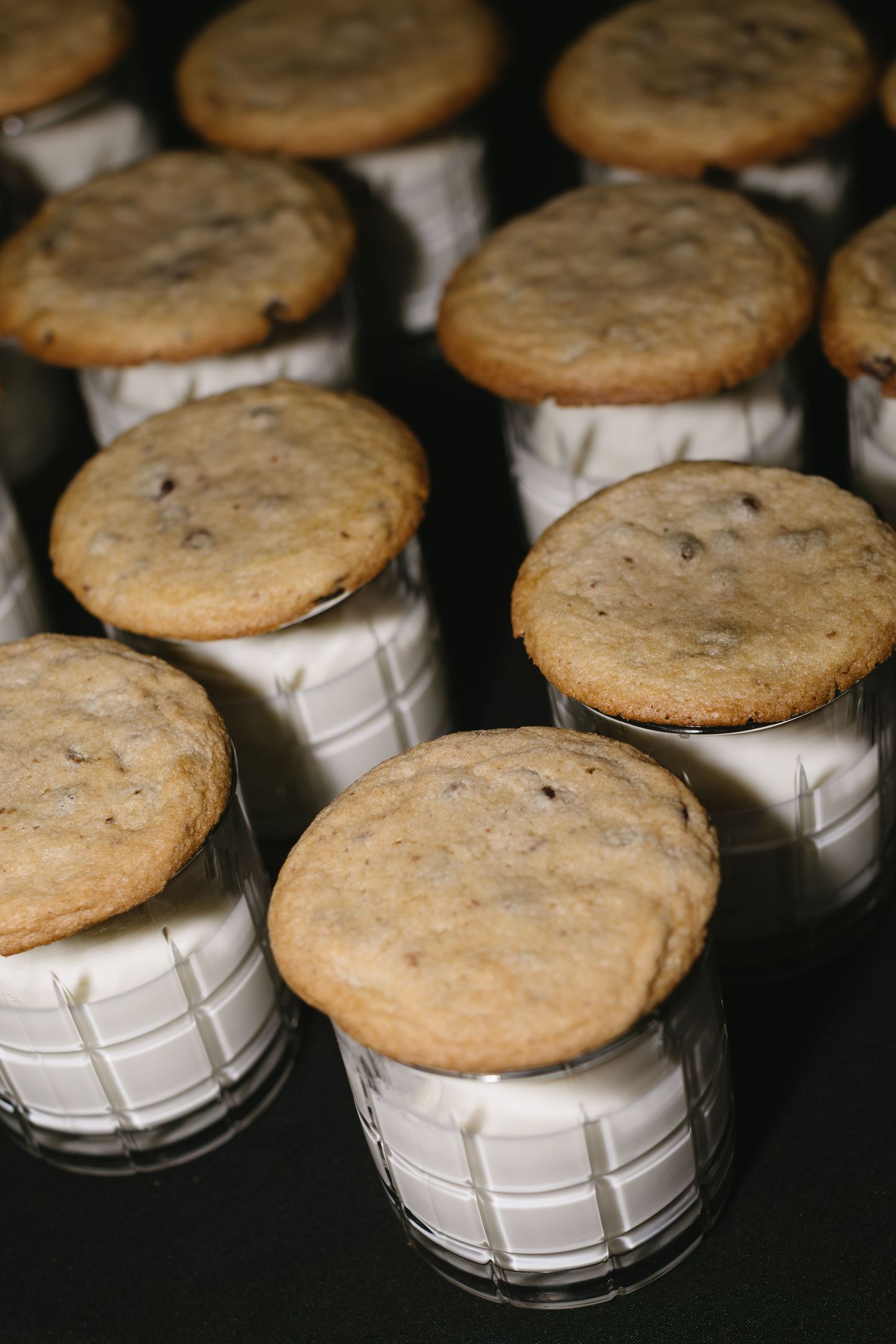 Chocolate chip cookies placed on white ceramic holders arranged in neat rows.