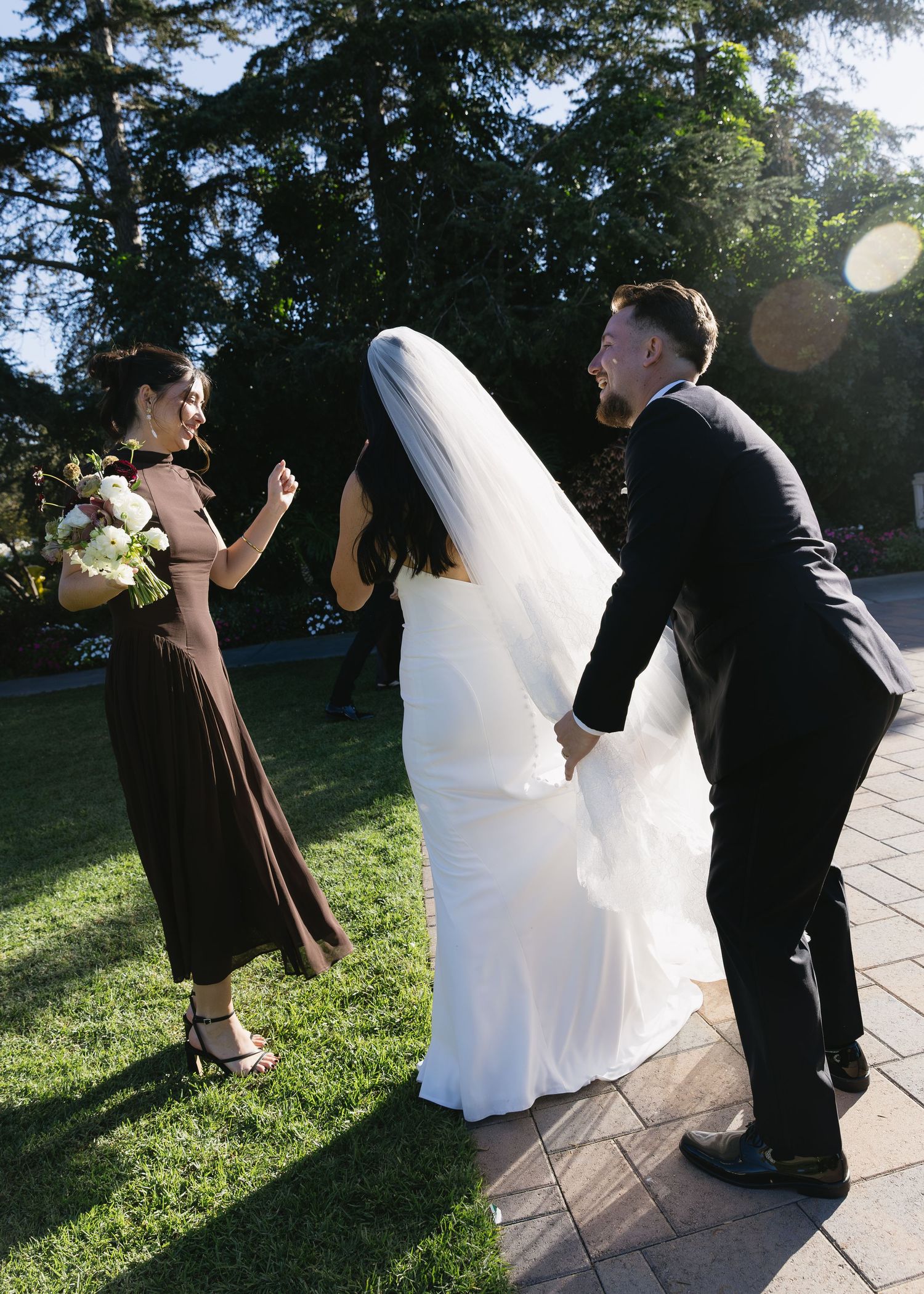 Wedding party celebrates on outdoor patio during golden hour.