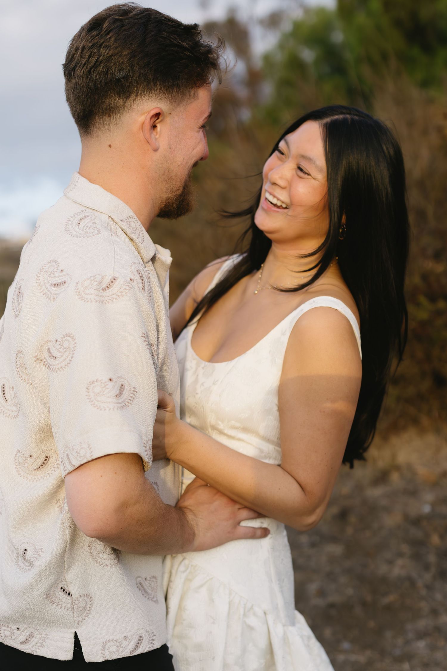 A romantic couple in white outfits embracing in a series of intimate outdoor photos.