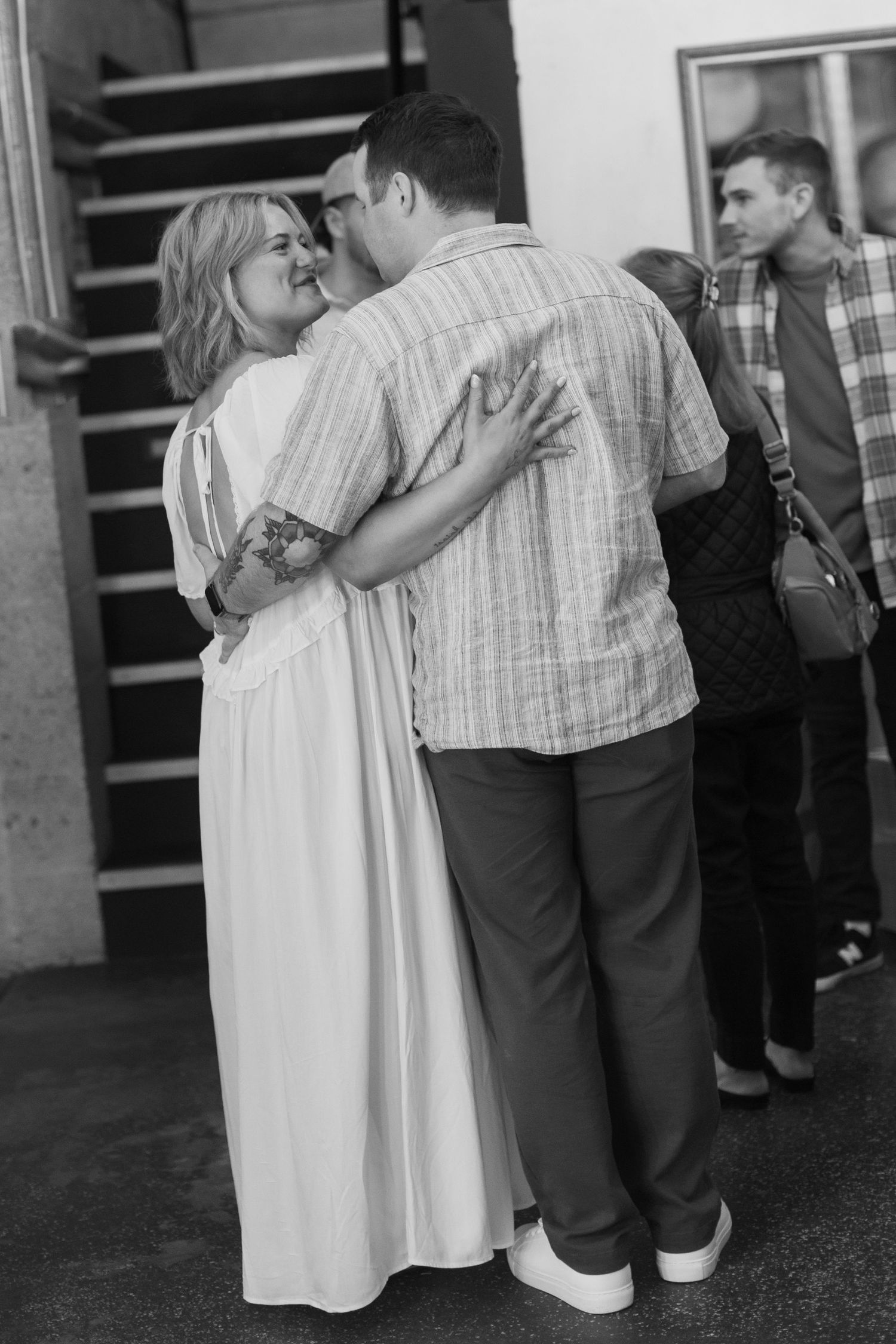 A couple embraces during what appears to be a wedding ceremony or celebration.