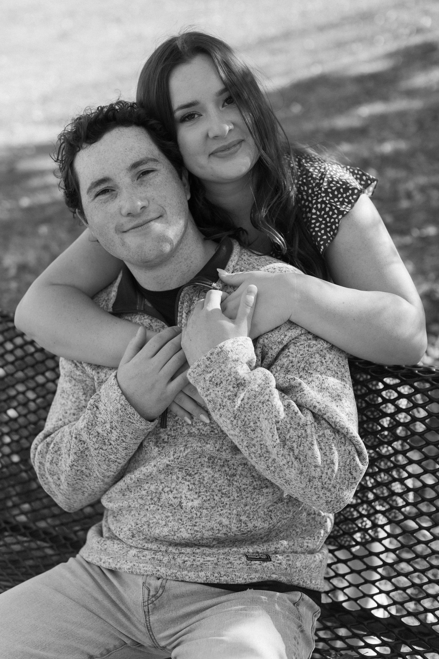 A black and white series of intimate couple portraits taken on a metal bench outdoors.