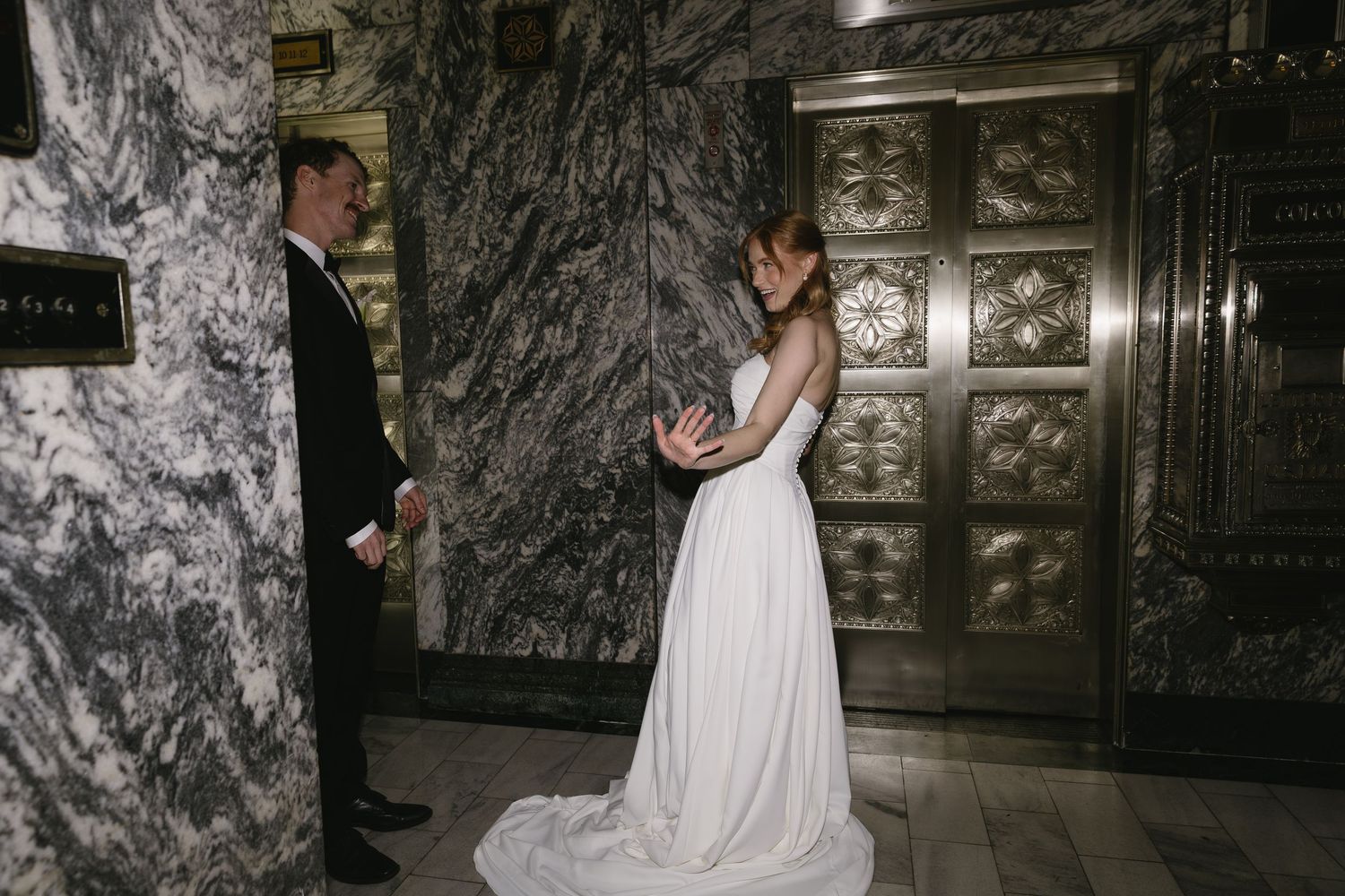 Elegant wedding portraits captured in a marble-walled hallway with ornate details.
